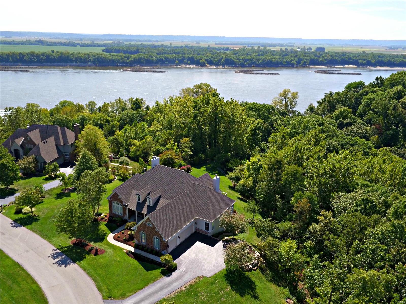 RARE OPPORTUNITY for year round Mississippi views, a large backyard AND gated subdivision living! There's generous amounts of outdoor entertaining space to enjoy the beautiful water views-- a newer deck, a large paver patio, and a pergola over an outdoor fireplace! The open air setting and gorgeous views are perfect for hosting weddings, rehearsal dinners and other memorable events! The atrium windows really bring the views inside. The Great room, Hearth room, eat-in kitchen and master bath all have a front row seat to the river and wildlife!. The interior features an open floor plan, neutral paint colors, tall ceilings, vaulted ceilings, custom built-ins, decorative pillars, crown molding, ceiling medallions, arched openings and more!The atrium lower level has 1,200+ finished sq ft and 2,000+ unfinished sq ft! Every bedroom has a walk-in closet and is attached to a full bathroom! Come see this Fischer and Frichtel signature home!