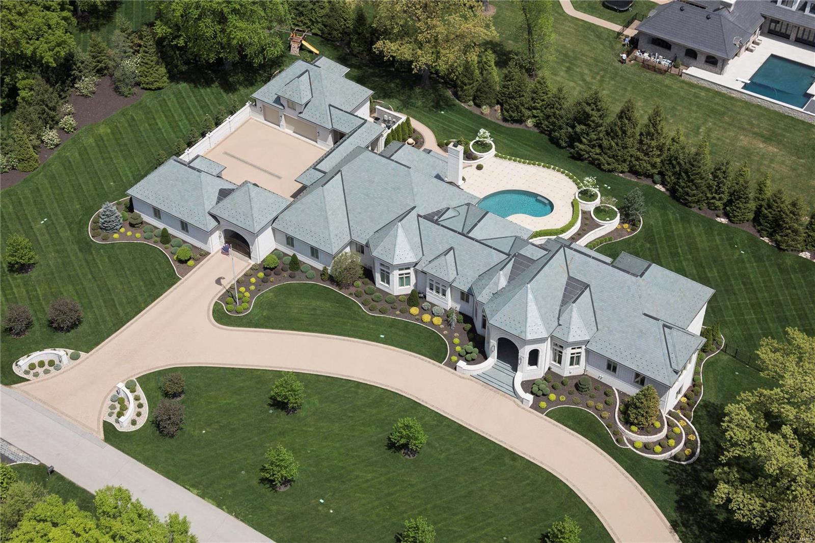 Resplendent Huntleigh estate selected by The Robb Report as Mid-West’s singular statement of architectural excellence and design, one-of-a-kind, worldwide. Established 9 years ago, taking 2 years to build, in standards 2 to 3 times that of the industry. The home’s technology is continually evolving, being updated regularly to remain a state-of-the-art composition. Entry through the porte cochere through a motorized gate leads to a paver parking court, 8-car garage and carriage house. Appointments include Geothermal heating/cooling, a 125 Kw generator, saltwater pool, elevator, soundproof and fireproof concrete floors, 18 foot ceilings, and discerning details in rich woods, natural stone, etched glass and air conditioned terraces. 5 Bedroom suites, 9 baths, 12,000 SF with a main level Primary wing. Fully functional and easily managed. Exceptional outdoor space. Covered balconies overlook manicured grounds. Additional amenities: Lounge, billiard & craft rooms, theater, exercise room.