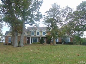212 +/- acres-fronting Hwy D, combination of woods & pasture, approx. 30% in pasture & food plot.  Improvements include a 1 1/2 story brick and frame home built in 1993. Features include: gourmet style kitchen, spacious living rm with fireplace, formal dining rm, huge game rm with stone fireplace, 2nd story has 4 bedrooms and 3 full baths. Huge master bedroom suite has a raised Jacuzzi & separate walk-in shower! Attached 3 car garage, full basement, covered front & back porches, and unbelievable views! Gated entrance with white vinyl fence lined driveway!  All electric, septic, public water. Additional Rooms: Mud Room