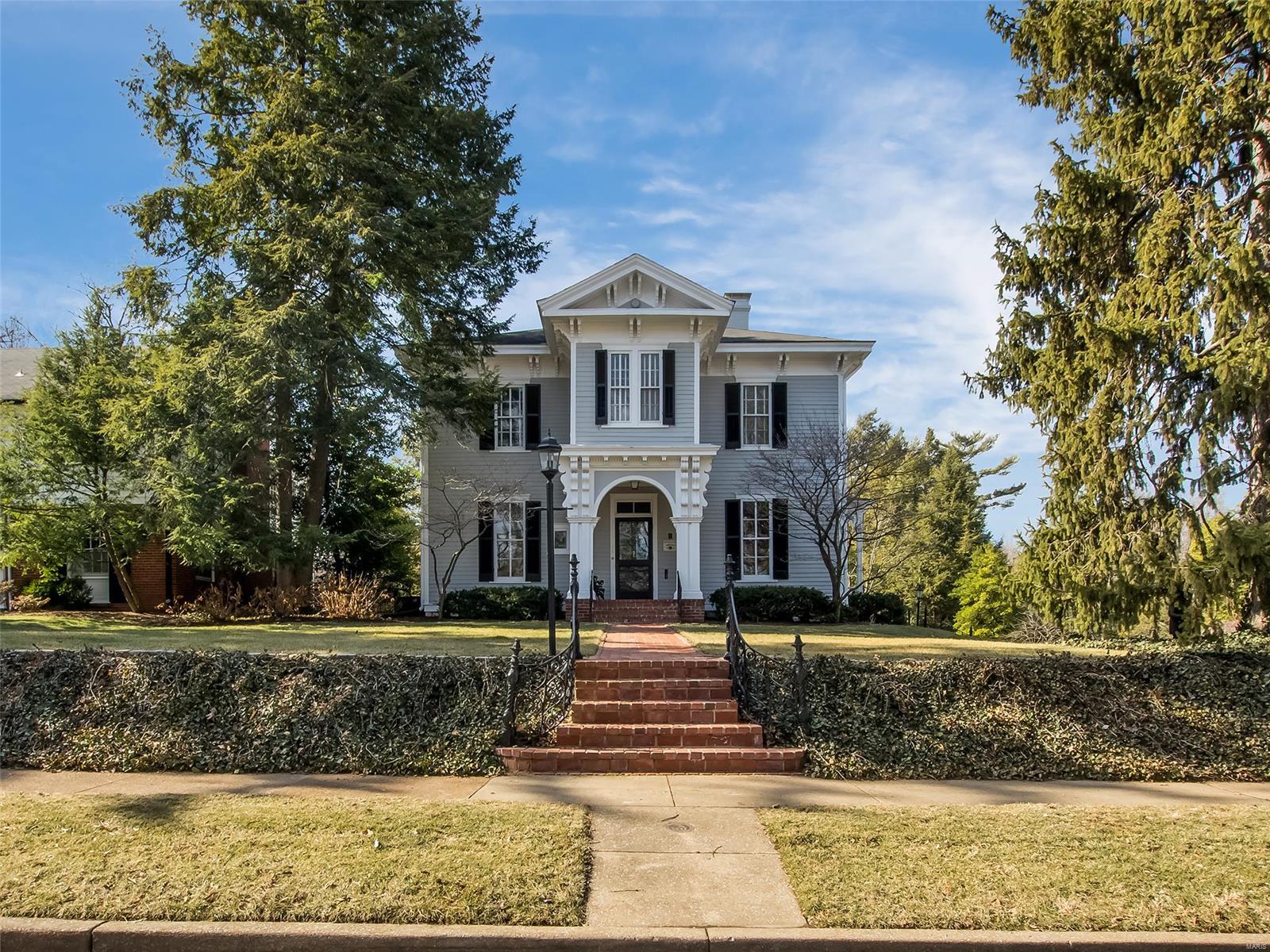Selected a St. Louis County Landmark for its beautiful Italianate architecture, this iconic Webster home, built in 1868, showcases meticulous attention to historic detail while being totally updated for life today. A wide center hall offers welcome. Huge living room with built-in bookcases, alcoves and bays provides multiple seating areas, access to porch. Ceilings soar to past 11 ft. Beautiful millwork graces rooms. Hickory floors gleam. Gorgeous floor-to-ceiling windows provide views of the .6 acre, low maintenance, park-like yard. Large custom kitchen, with a lovely center island, combines state-of-the-art appliances with old world detailing. Kitchen opens to both a cozy den with fireplace and large screened porch, perfect for outdoor living. A beautiful walnut staircase leads to the master suite with marble bath, over-sized shower and walk-in closet. Four additional bedrooms and a hall bath complete the second floor. Just two blocks away Downtown Old Webster/Bristol School await.