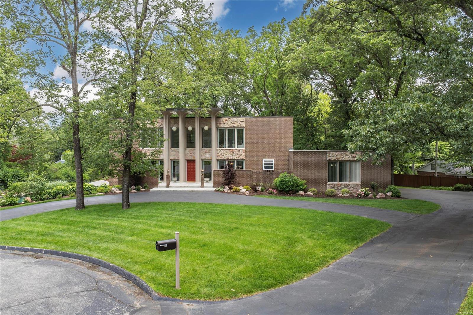 Spectacular mid-century modern, 2-Story home, situated on a beautiful, wooded 1.75-acre park-like, cul-de-sac lot, in the heart of Frontenac. 5 Beds, 5.5 Baths & 5,100+ sqft of total living space including the finished Lower Level.2-Story Foyer with terrazzo floors & beautiful floating staircase! Main Floor boasts Living Room with custom moldings; Great Room with dramatic stone FP, huge windows & formal Dining Room with full view, sliding glass doors. Kitchen with custom cabinets, granite, tile backsplash, breakfast bar & top of the line SS appliances, as well as a Breakfast Room & a lovely Powder Room, complete 1st Floor. 2nd Floor finds hallway with wall of windows, leads to Master Retreat with Sitting Room, a spa-like Master Bath & dual walk-in closets. Awesome LL with large Rec Room, wet bar, brick accent wall with built-in FP & full view sliding glass door, the 5th Bed, 2 Baths & walk-in cedar closet. Relax in your private oasis & enjoy the free form in-ground pool!