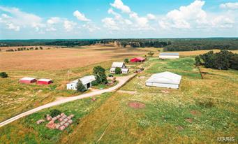 Spreading over 617 M/L acres and encompassing a golden sea of rolling bromegrass hayfields, cross fenced pastures, and annual fields combined for seed. Conveniently located is the central working hub consisting of a 3+ acre piped corral system with two hay barns, machine sheds, and a 50x70 covered working facility with squeeze chute/concrete loading ramp as well as alley ways and sorting/holding pens. Ponds and waterers strategically located in every cross fenced pasture allows for easy rotational grazing.  While being over 90 % open pasture the scattered timber in the draws provides good cover for livestock and wildlife. One of the stands of timber has an improved spring branch that’s been upgraded with concrete foundation. Electric on site/ Tons of road frontage and future building sites for your ranch home! Property currently under farm lease until December 31