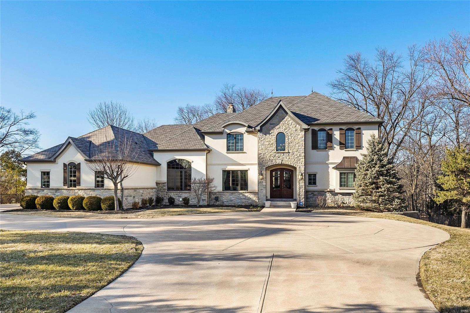 Completed in 2006, this French inspired masterpiece is defined by custom finishes and exquisite millwork - box beams, extensive crown molding, paneling, built-ins and arched openings. Chef's kitchen equipped with professional appliances, commercial style hood, premium granite counter tops, butler's pantry & separate walk-in, over-sized center island, and custom cabinets w/ full extension soft close drawers and layered crown molding. Mstr suite w/ luxury bath & expansive closet. 2nd Floor includes 9' ceilings, plush carpet, loft and 3 spacious BR's - each w/ bath & walk-in closet-complete with custom laminate shelving. Spectacular lower level features 2 bedrooms, wine cellar, exercise room, cedar closet, theater, wet bar, separate dining, family room with wood burning fireplace and patio access. Its proximity to upscale shopping, fine dining, prestigious schools, parks, walking trails, major highways and hospitals make it the ideal location for anyone residing in the St Louis area.