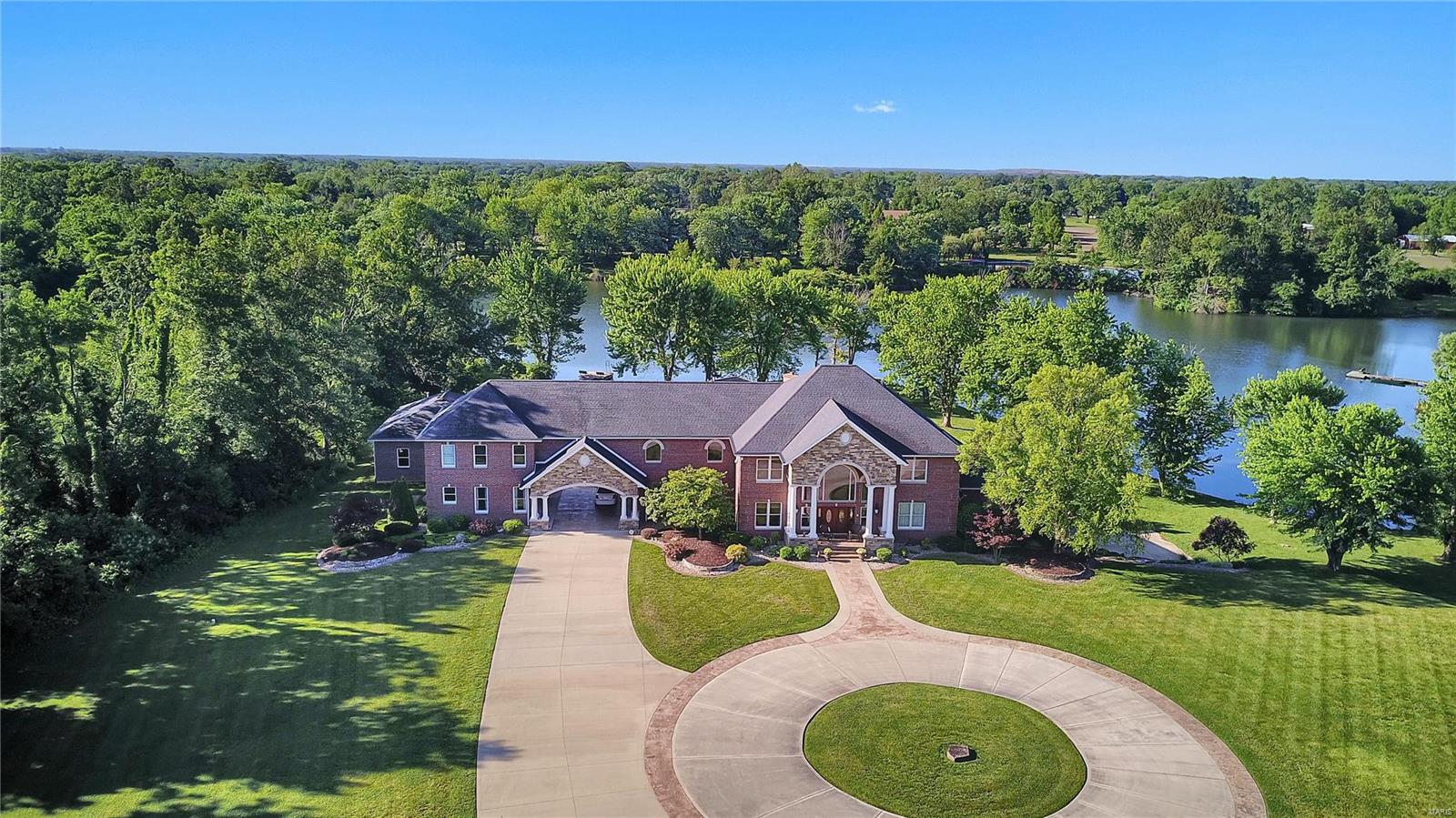 NEW PRICE!  YOUR "STAY-CATION" AWAITS!  POOL, OUTDOOR KITCHEN, HOT TUB & LAKE!! 2 story waterfront home is nestled on 13.5 acres of bliss. Built in 2003, the impressive 6 bedrm/9 bath all bundled w/ quality craftsmanship & style- on steroids! Spectacular features: theatre rm, bar area/game area -Wonderful open floor plan boasts a main floor master suite w/spa-like en-suite. Pamper your inner chef w/the gourmet kitchen featuring high-end Wolf stainless steel appliances, granite counter-tops, gorgeous cabinetry, butler's pantry & more! There's room for everyone about this 11,000 sq. ft. estate- extended family & guests will appreciate the in-law's quarters complete w/kitchen, bedrm, bath & living area. All this space, yet cozy enough to feel right at home. Explore & entertain outdoors about the in-ground pool w/ hot tub, outdoor kitchen/bar area or sit lakeside & enjoy the tranquil oasis. A pass-thru drive leads to 6 car garage. So much to see & appreciate -photo's can't capture it all. Additional Rooms: Mud Room