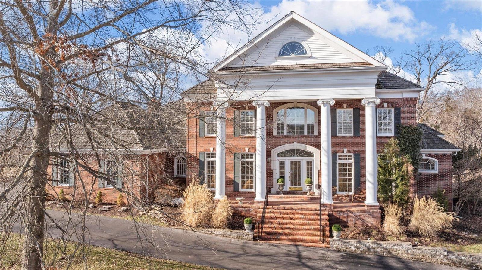 Nestled within the Saint Albans country club grounds and perfectly situated overlooking the 17th tee of the Lewis & Clark course, this spectacular estate is an oasis of grand living. As you enter into the stunning two-story foyer, your eyes are immediately drawn into the great room and the panoramic views that lie beyond. This brick 6-bedroom, 5-bath, colonial seamlessly blends luxury with everyday living. Highlighted by high ceilings, openness, abundant light and nearly 7000 total living ft.², the home features a main floor primary bedroom, sun-drenched study and updated kitchen with adjacent hearth room & deck access. 3 gas fireplaces, two bars, hardwood floors and newer carpeting further enhance. A lower level with a $130,000+ renovation provides add'l living and entertaining space as well as a walk-out to the beautiful paver patio and spectacular landscaping. Whether you enjoy golf or just want to partake in the gorgeous year-round sunsets & tranquil setting, this home is perfect!