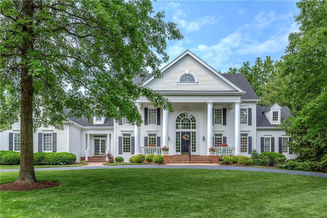 A truly magnificent 1.5-sty Southern Colonial in prestigious Manderleigh Estates! Grand 2-sty marble foyer highlighted by dramatic curved staircase leads to library-paneled study with built-in bookcases, elegant dining room with palladian windows & step-down great room with 2-sty wall of windows, marble fireplace, wet bar & French doors to patio. Designer kitchen with granite countertops, 42” cabinetry, premium appliances & center island adjoins light-filled breakfast room with bay window and vaulted hearth room with brick fireplace flanked by built-in bookcases. Coffered master bedroom suite with 2 walk-in closets & beautifully appointed bath with Jacuzzi offers an appealing retreat. Front & rear staircases access 3 additional bedroom suites with generous room dimensions. Builder-finished walk-out Lower Level includes recreation room with fireplace & wet bar, game room, media room & guest suite with family room. Extensively landscaped 1-acre lot with patio, Koi pond & 3-car garage.