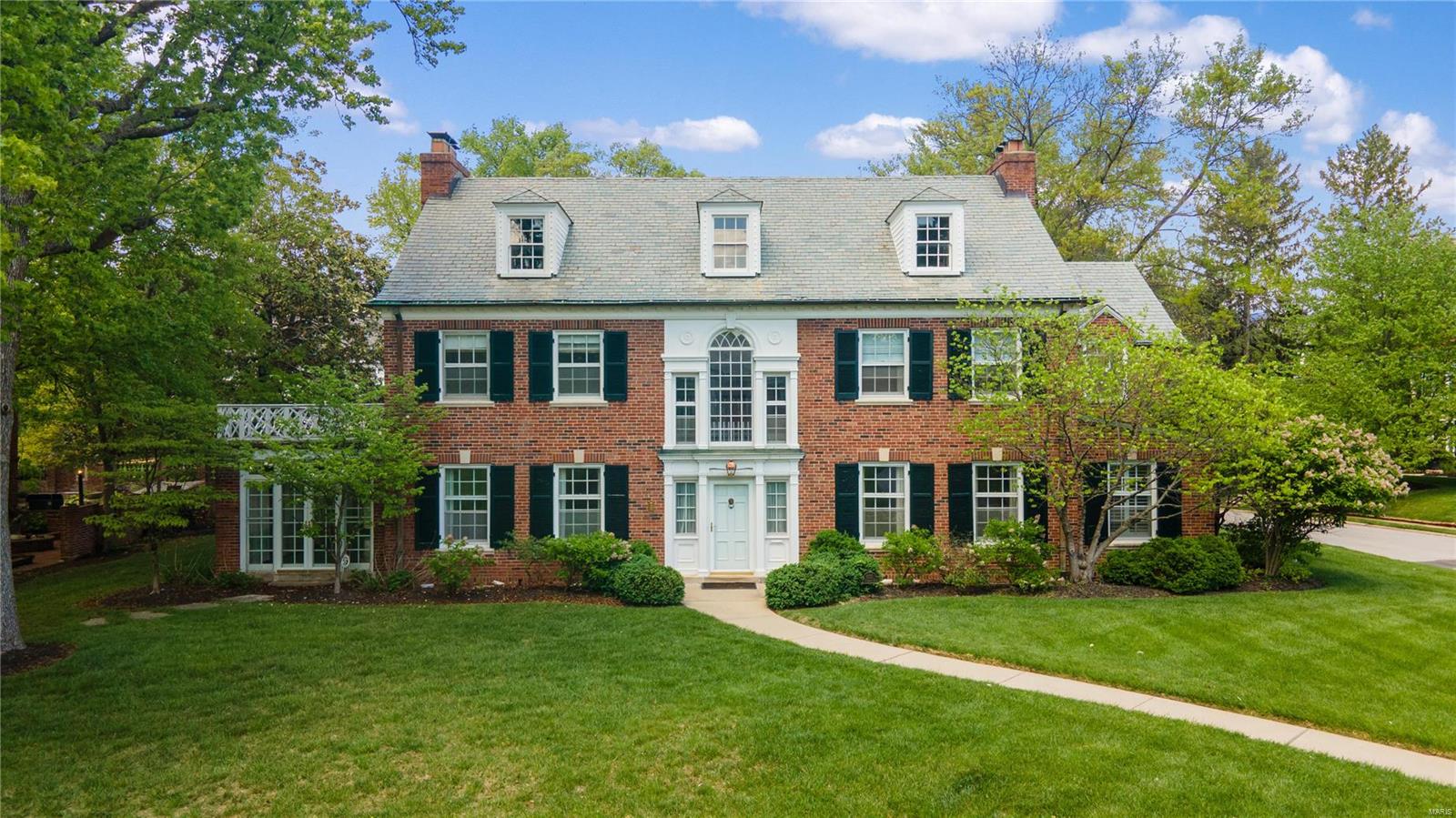 303 W. Jackson Road is a stately brick Colonial 3-story home located in the heart of Webster Groves on a charming corner lot.  The expansive floor plan blends historic features w/modern updates seamlessly.  The wraparound staircase, w/stunning light filled landing, would be the best spot for every special occasion photo op.  Living & dining spaces are formal w/tall ceilings, painted moldings & herringbone wood floors, but generously sized; a designer dream to furnish.  The paneled family room, is tucked away, window-lined & has original terrazzo floors.  Gourmet kitchen w/eat-in area, custom cabinetry & butler’s pantry plus mudroom to keep you organized.  The primary suite is accessible from back staircase w/in the custom closet.  Find 3 more large bedrooms & full bath on 2nd fl.  Bonus 3rd fl ~ 775sf, is an open footprint, framed & ready to be finished. Lower level family room, storage, attached garage & brick patio complete this amazing home. Walkable to WG eats, shops & schools. Additional Rooms: Mud Room