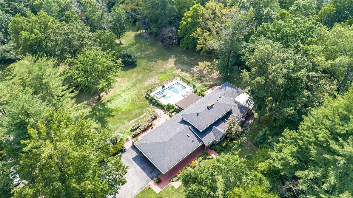 Unbelievable opportunity to build your dream home or renovate the existing home situated on 3 spectacular, private, park-like acres offering a desirable Ladue location! The existing 1 1/2 story home features 6,056sqft, 4 bedrooms, 3.5 baths. The main level includes:  entry foyer, living room with fireplace, dining room with built-in buffet, powder room, family room/game room with restaurant like built-in bar and built-in entertainment center, kitchen with granite counters, breakfast room, master bedroom suite, master bath, bedroom 2 suite with full bath. Second level: bedroom 3 & 4, full bath. Partially finished lower level with storage areas. The backyard includes: patio, pool, unfinished pool house with electricity. Two car attached garage.