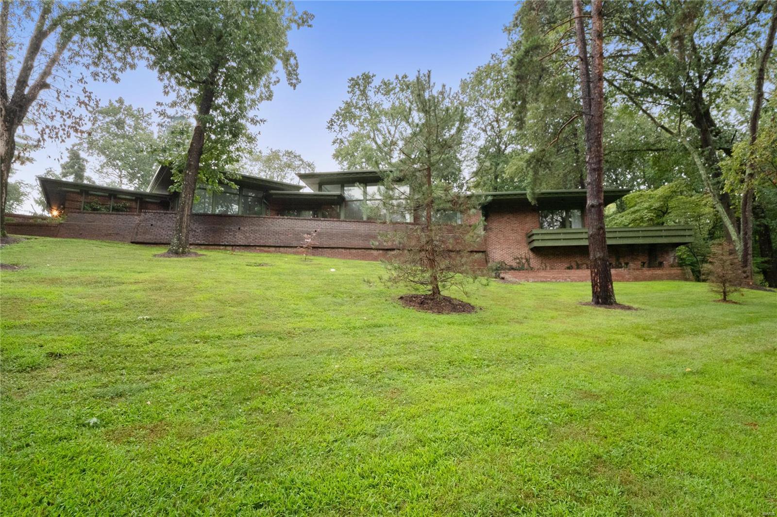 Fantastic opportunity to renovate this unique, gem, located on a 2.3 acre lot located in desirable Ladue School District. It is also the perfect lot for a tear down to build your custom dream home! This mid century ranch home offers a lot of special characteristics, some of those features include 12' ceilings in the main living areas, floor to ceiling windows, 2 gas fireplaces, a centrally located, enclosed wet bar, a walk in safe, a lower level wet bar/recreational room, multi zoned HVAC system, and a large dining room, adjacent from the kitchen. Some exterior features include 4 sides brick, a 60 Mil TPO membrane roof, an oversized 3 car garage, and a detached 6 car (tandem) garage with heaters. The outdoor living space includes an inground swimming pool that is nestled among mature landscaping with an entertaining area perfect for family and friend gatherings. This property is being sold "As Is". Seller to do no inspections or repairs. Inspections are for the buyers knowledge only.