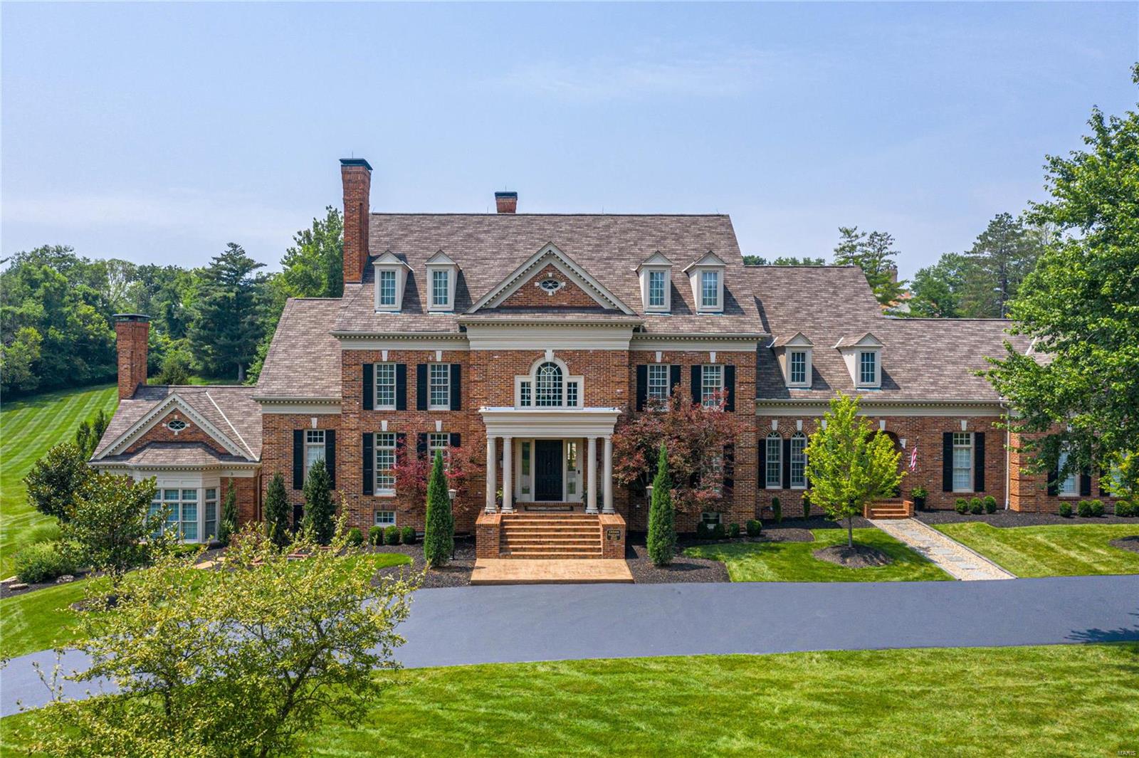 Magnificent 1.5-sty Georgian Colonial on parklike 1.8-ac grounds. Grand 2-sty marble foyer opens to private study with marble fireplace & built-in bookcases, beautifully appointed dining room & stunning great room with arched entryways & stone fireplace. Designer kitchen featuring 48” white cabinetry, granite countertops & commercial grade appliances adjoins breakfast room with groin vault ceiling & serving bar & vaulted hearth room with floor-to-ceiling fireplace & French doors that open to sunroom. Sumptuous master bedroom suite with marble bath with shower spa offers an appealing retreat. The 2nd floor extends the living quarters with 5 additional bedrooms, bonus room with fireplace & 3 full baths.  Lower Level includes recreation room with 5th fireplace, family room, wet bar, 2nd kitchen, office, workout room & 1 full & 2 ½ baths. Atrium doors open to outdoor living area with resort style pool & pool house surrounded by landscaped gardens plus grilling station & patio with firepit. Additional Rooms: Sun Room, Wine Cellar
