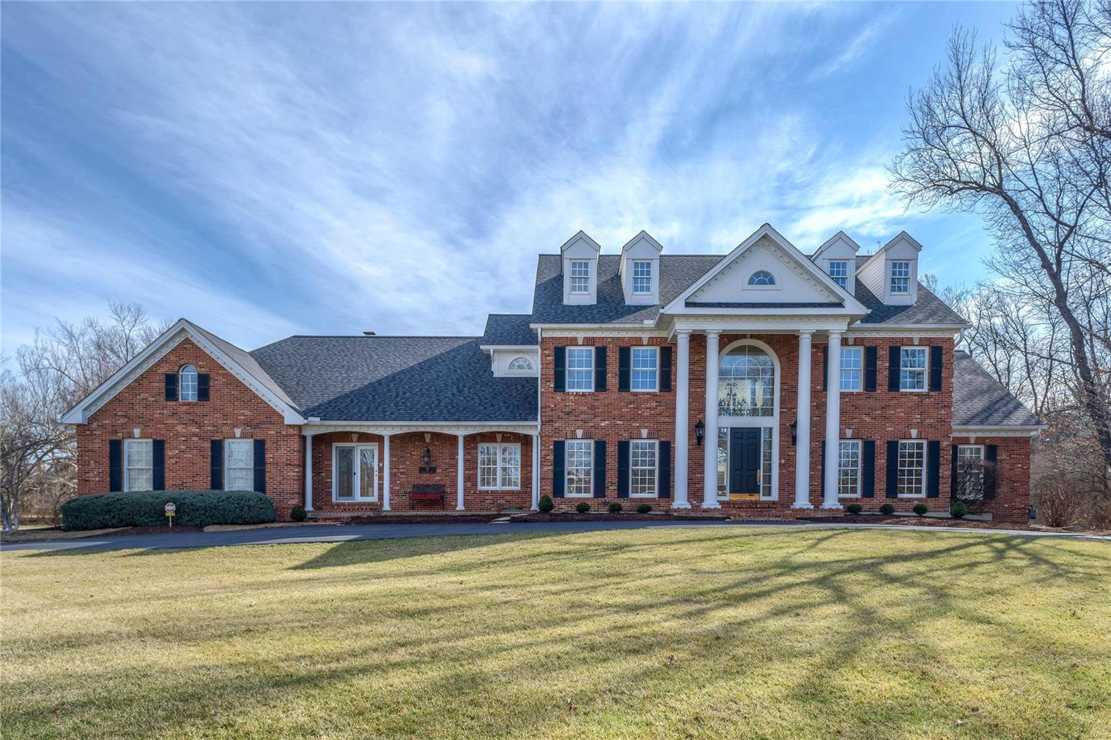 Magnificent 1.5-sty Georgian Colonial on 1-acre grounds! Grand 2-sty marble foyer highlighted by sweeping staircase leads to private study with custom built-ins, elegant dining room & spectacular great room with granite fireplace, wet bar & dramatic wall of windows. Designer kitchen features 42” maple cabinetry, granite countertops, professional quality appliances, center island & butler’s pantry. Light-filled breakfast room with convenient planning center & vaulted hearth room with floor-to-ceiling brick fireplace flanked by built-in bookcases provide a welcoming gathering place. Coffered master bedroom suite with wide bay window, 2 walk-in closets & lavish bath plus a spacious guest suite complete the main floor living quarters. Front & rear staircases access 4 additional bedrooms & 2 Jack n’ Jill baths. Incredible walk-out Lower Level includes recreation room with wet bar, game room, office/workout room & full bath. Extensively landscaped lot with deck, patio & 4-car garage.