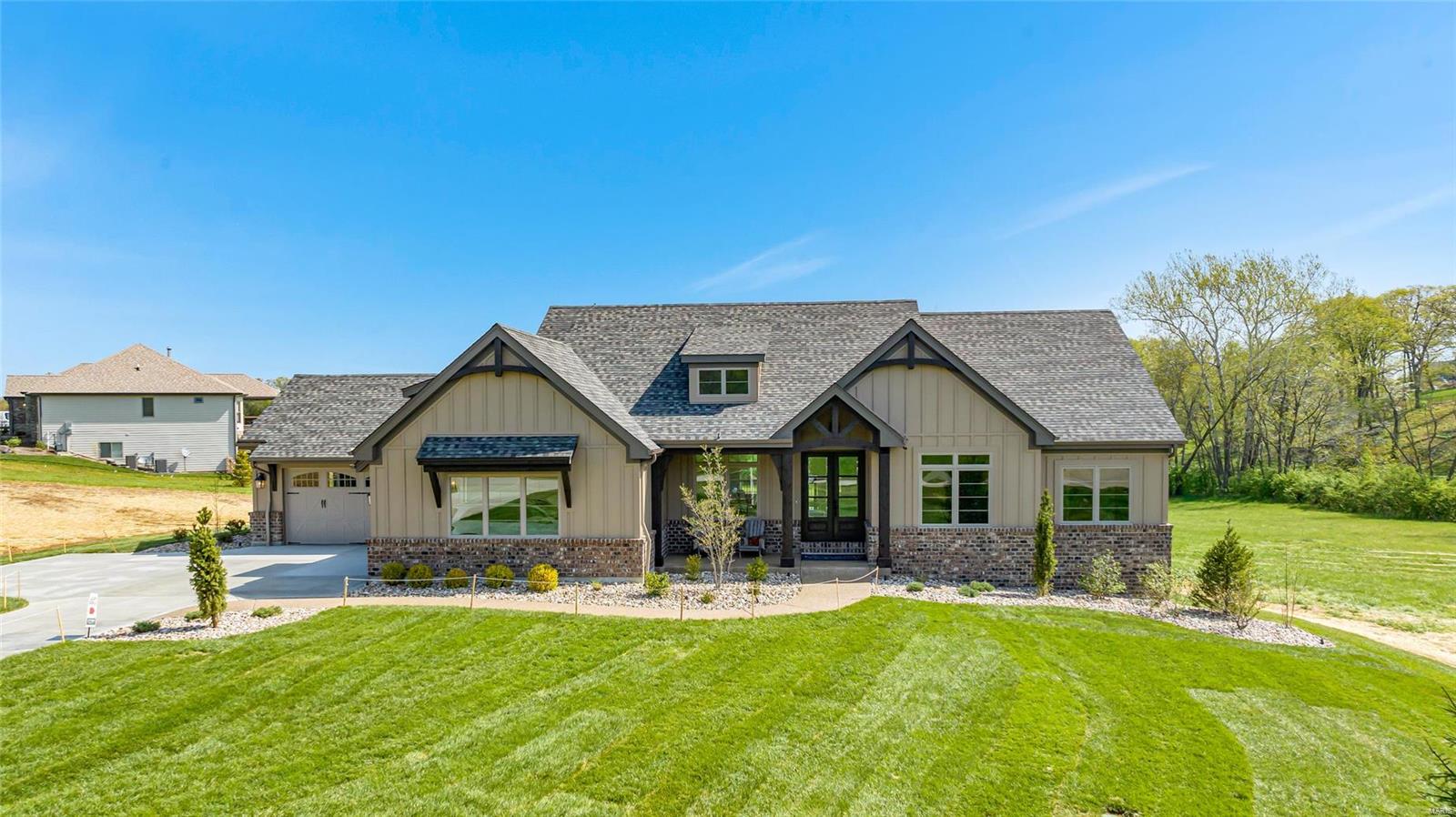 Stunning atrium ranch on 3 acres farmhouse exterior w/stone & wood beams,4 car garage, aggregate walkway, porch & patio. The 9' main/11' ceilings in great room w/stone fireplace, gorgeous hardwood floors, stair railings with iron balusters, oversized baseboards & crown molding with arched doorways on the main floor make for a rich look. Gourmet kitchen has well lit breakfast room, elegant granite, custom cabinets, JennAire appliances and center island for great entertaining space and family living. The master bedroom suite has his and hers granite counters, large walk in closet, upgraded carpet, high end fixtures and beautiful ceramic tile. The main floor has a mudroom, laundry room and office. The lower level will be a perfect space to relax w/another stone fireplace, living area and 3rd bedroom. The wooded lot is peaceful and will beckon you to spend time outside on the patio. The luxury is evident and the quality cannot be matched.