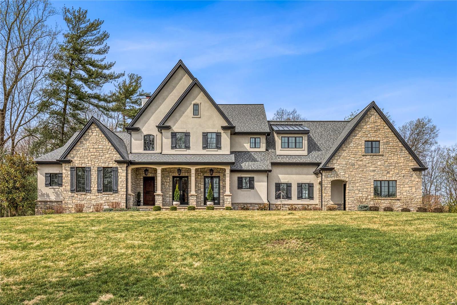 This spectacular stone & stucco 1.5 Sty features an open floor plan with oak hardwoods, soaring ceilings & extensive millwork. Impressive 2-sty entry foyer leads to private study with tray ceiling, custom built-ins & 2 sets of French doors & stunning great room with 11’ box beam ceiling & cast stone fireplace. Designer kitchen with 42” white cabinetry, quartz countertops, commercial grade appliances, 10’ center island & butler’s pantry adjoins light-filled breakfast room & vaulted hearth room highlighted by floor-to-ceiling stone fireplace. Coffered primary bedroom suite with customized walk-in closet with laundry & luxury bath with steam shower & freestanding tub offers an appealing retreat. Oak staircase accesses 3 additional bedrooms, 2 with Jack n’ Jill bath, hall full bath, bonus room, office & convenient laundry.  Situated on parklike 1+ ac grounds with covered patio with full-height fireplace & oversized 3-car garage. Neighborhood community with clubhouse, pool & tennis courts. Additional Rooms: Mud Room