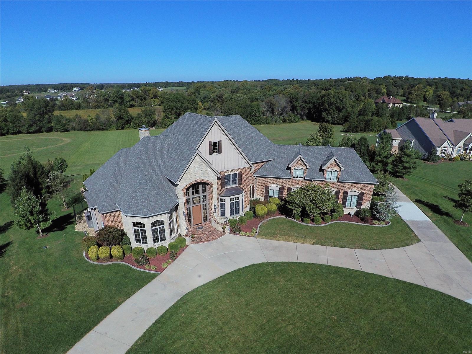 Magnificent estate home situated on over 4 acres with expansive views and inviting lavish entertaining inside and out. Grand two story entry with stunning staircase opens to the two story great room with wood floors, fireplace and wall of windows. Impressive showroom quality chef’s kitchen features high end appliances, granite, endless walk-in pantry, prep sink and custom tile backsplash. Adjacent are the hearth and breakfast rooms boasting reverse wood vault making this the space everyone wants to gather. Spacious master suite features luxurious bath with walk-in shower, stately soaking tub and dual walk-in closets with washer and dryer. Upstairs are four additional bedrooms with loft. The lower level is free flowing with large entertaining spaces, screening room, temperature controlled wine storage, private exercise room and full bath. The lush, manicured yard welcomes guests with a salt water pool, fireplace, covered and open seating areas, and BBQ area. Additional Rooms: Mud Room