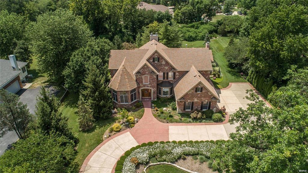 Spectacular brick & stone 1.5 Sty w/over 5600 sf of living space enhanced by maple hardwoods, soaring ceilings, custom build-ins & integrated sound system. Impressive 2-sty foyer leads to library-paneled study w/groin vaulted ceiling, elegant dining room & stunning great room w/full height fireplace flanked by 2-sty windows & atrium doors to veranda. Designer kitchen w/42' maple cabinetry, granite countertops, 8' center island & convenient planning center adjoins vaulted breakfast room w/wide bay window & hearth room highlighted by marble fireplace. Coffered master bedroom suite w/luxury bath w/jetted tub offers an appealing retreat. T-staircase accesses 3 additional bedrooms, 1 w/ensuite bath & 2 w/ Jack n' Jill bath. Walk-out Lower Level includes recreation room with gathering bar & 3rd fireplace, game room & media room plus workout room & full bath with sauna. Situated on a 1-acre lot with a brick and stone veranda, loggia & resort style pool surrounded by landscaped gardens.