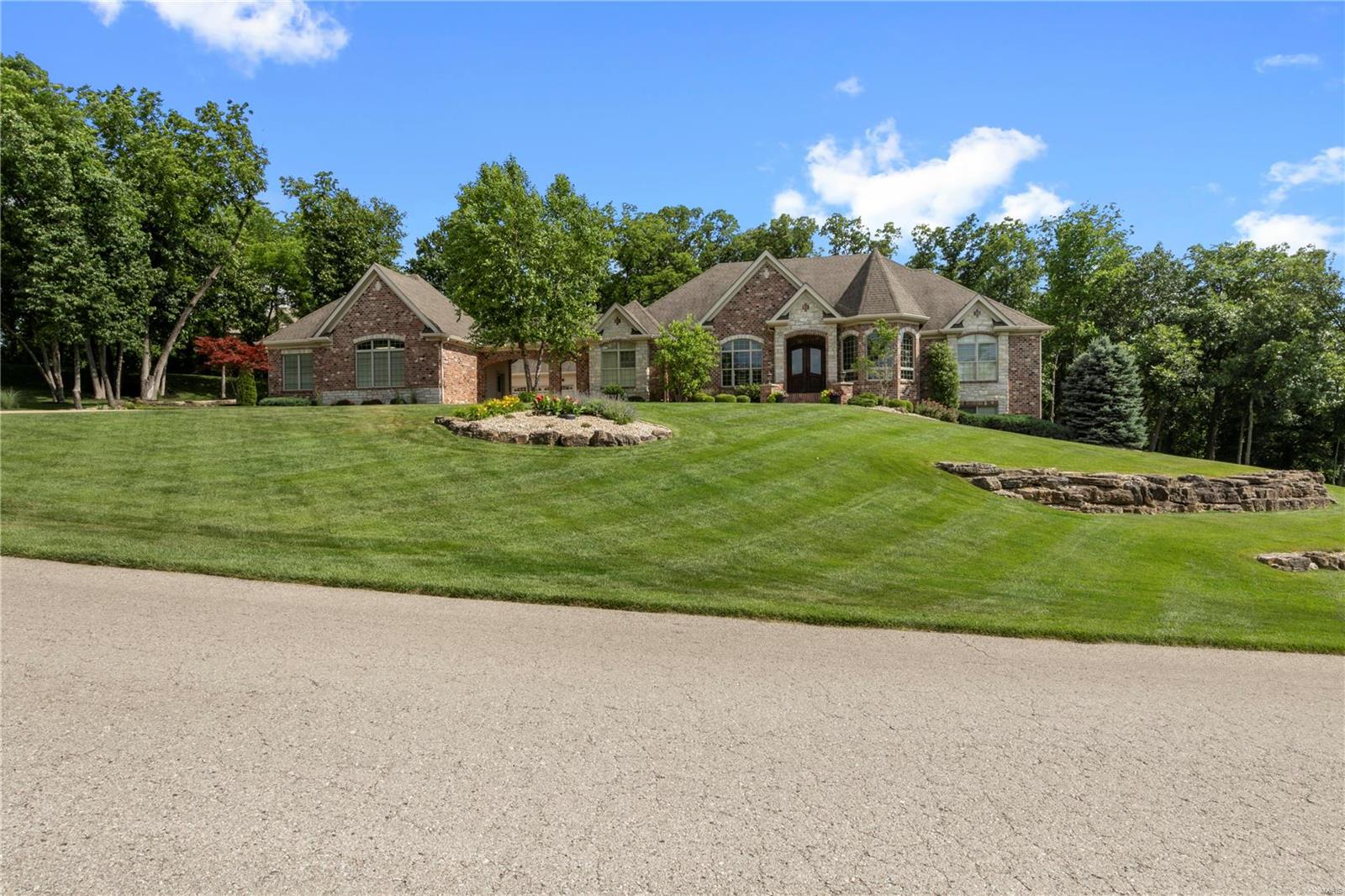 GORGEOUS 3 BR 5 BA Brick & Stone Bax custom home! Perfectly nestled on 3 ACRE wooded lot in gated community of Stonecastle! SO MUCH Detail! 5-Inch Hand Scraped Hardwood Floors! Vaulted Great Room w/Gas See-Thru Fireplace! SALT WATER POOL!24x20 covered patio w/OUTSIDE FIREPLACE!  5-In Hickory Hand Scraped Hardwood Floors! All 3 BEDROOMS ARE SUITES! Vaulted Master BDR w/wall of windows overlooking pool & mature trees. 
Custom Chef-style kitchen... 2 separate Granite Island/Counter work space for family meals, morning coffee & Conversation! Microwave drawer, gas cooktop, DOUBLE Electric ovens, Walk-In Pantry!  UPGRADED Lighting.. WIRELESS SUROUND SOUND....Dual HVAC; 2 TANKLESS WATER HEATERS! SIX Garage STALLS! Sellers have added Approx.2200+ FINISHED LOWER LEVEL.HUGE Media Room, w/Bar, Recreation Room, AMAZING Fitness Center & Finished Powder Room! Framed & READY for a 4th BEDROOM SUITE! Additional FINISHED Work Room could be converted EASILY to 5th BEDROOM if Needed.