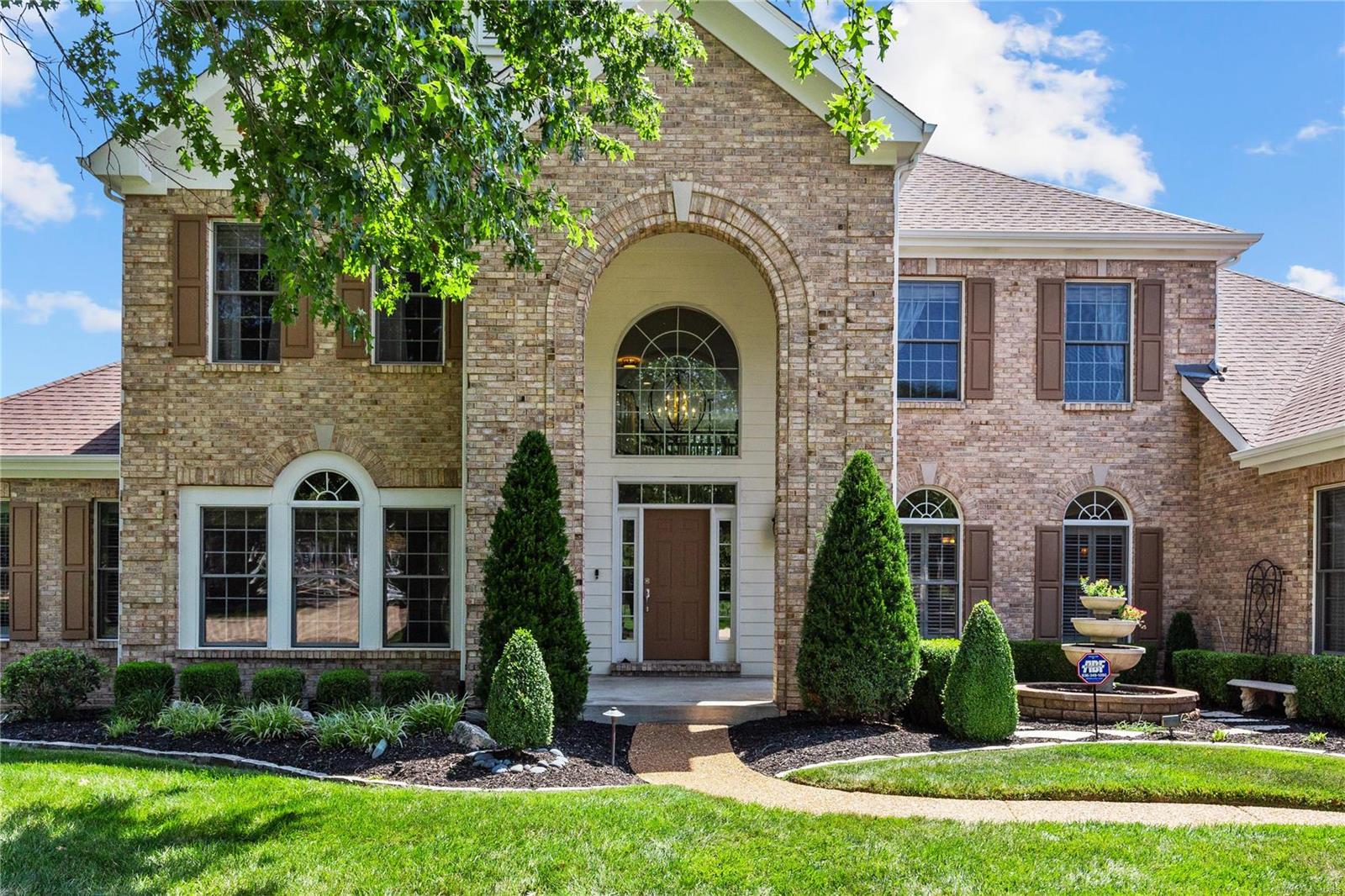 This exquisite 1.5-story home offers over 6,200 square feet of living space—the great room with soaring 20-foot-high ceilings. The main level includes the primary bedroom, laundry, and kitchen area. The eat-in kitchen is a chef's dream, boasting white 42" custom cabinets, a 5-burner gas cooktop, double ovens, granite countertops, and stainless steel appliances. The sunroom allows you to relax and enjoy the breathtaking views of the lush woods. The main floor primary suite is a luxurious retreat with an en-suite bathroom featuring a garden tub and a curbless shower. The upper level offers a large bonus room and three additional bedrooms, one with a private bath and the others sharing a Jack-and-Jill bathroom, all with walk-in closets. The lower level is spectacular, with a recreation room, gas fireplace, and a newly renovated entertainment area featuring a custom bar, dishwasher, fridge, and sink. An exercise room and a large fifth bedroom with a full bath complete the lower level. Additional Rooms: Sun Room