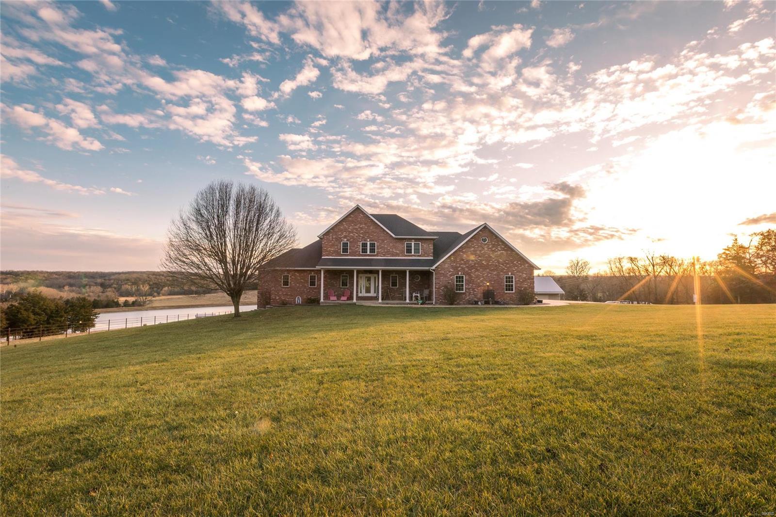 Eagle Lake Haven, located in the extremely sought Fatima R3 school district, features a gorgeous 4 bed, 4.5 bath home over-looking 59 +/- acres of prime central Osage County real estate. The custom brick home has 4934 sq ft of finished living with huge master suite, master bath, and walk-in closet. The open floor plan flows great with excellent views of the in-ground pool and 5.8 acre lake. The lower level is all about entertainment with large family rec room, game room and kitchenette. Step outside to the spacious pool side patio with built in bar and fire place. Acreage consists of mostly open fertile pasture with excellent perimeter and cross fencing along with metal corral and head gate system. Other improvements include a large hay barn, garage, lake pavilion, and shop with built in walk-in cooler.