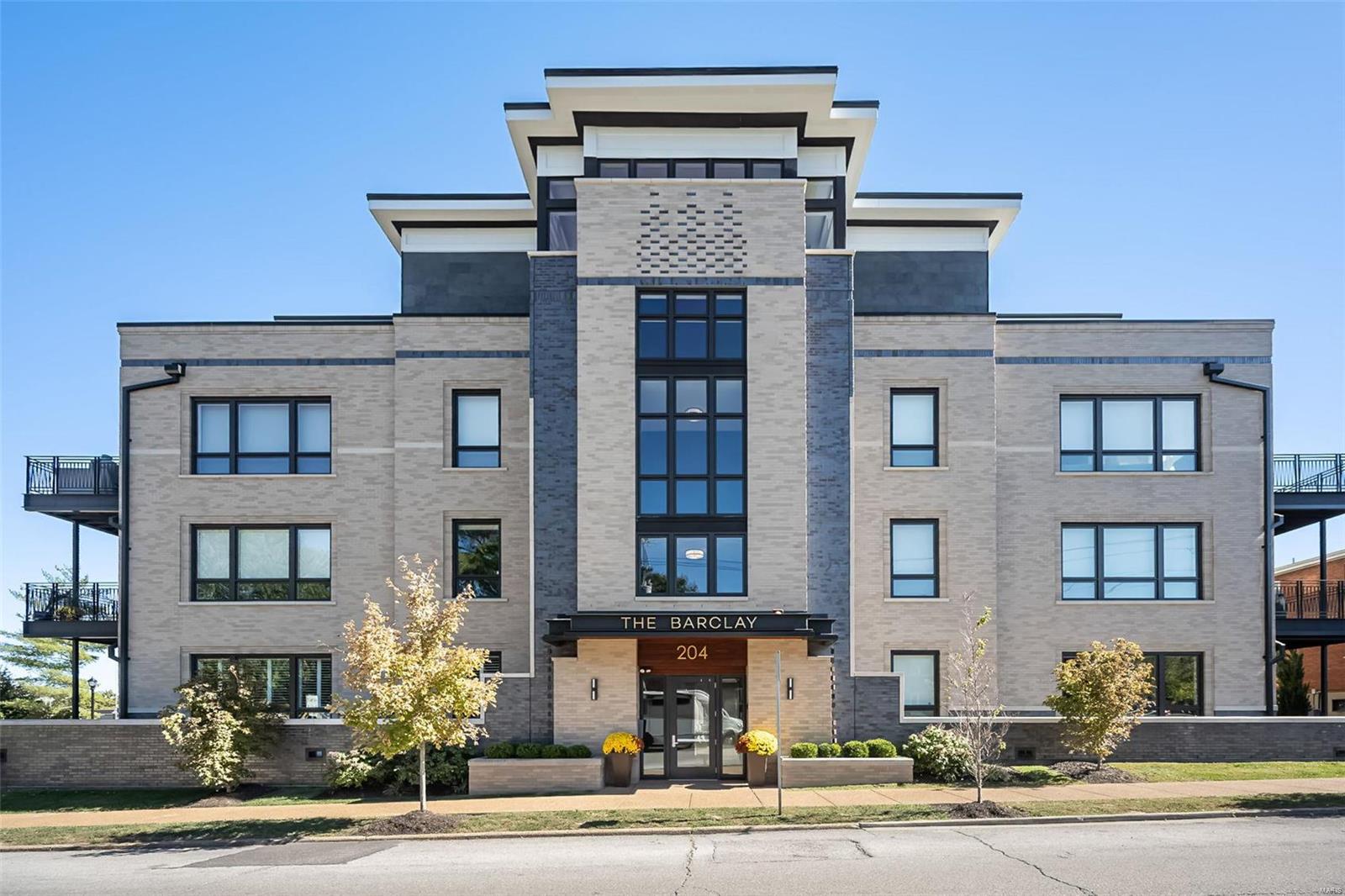 Step into luxurious living with this exquisite first-floor condo in downtown Kirkwood. Boasting 10 ft ceilings and over 1800 sf, this 2-bdrm, 2-bath home features floor-to-ceiling windows that flood the space with natural light. The spacious great room with gorgeous hardwood floors offers a custom fireplace framed by built-in shelving. You'll also find a versatile den, ideal for an office or library. The chef’s kitchen is the heart of the home, featuring a large granite island, double ovens & sleek finishes. The primary suite offers a peaceful retreat with a high end bath and custom closet. Throughout, custom plantation shutters add a touch of sophistication and privacy. Enjoy the 900+ sf terrace, with space for dining, gardening, or simply relaxing in your own urban oasis. Included are 2 heated garage spaces, a storage unit, and elevator service. The property offers a walkable lifestyle, blending modern elegance with neighborhood charm. Don’t miss the chance to own this stunning home! Location: Corner Location, Ground Level