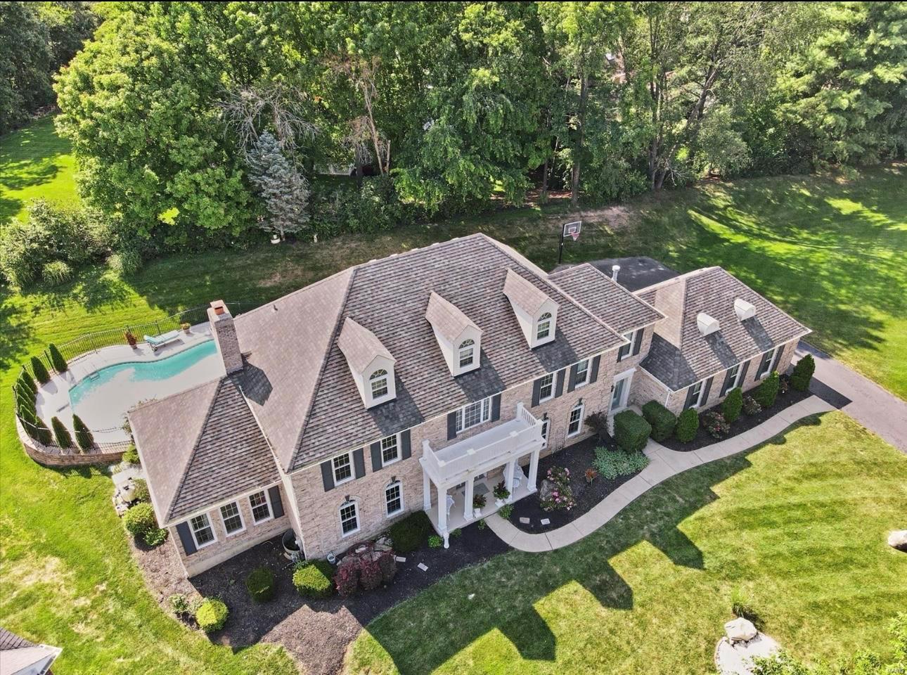 Seller is offering a one-year home warranty! Welcome to the highly sought-after Manors of Town and Country! This stunning home boasts an open floor plan with a marvelous fireplace, perfect for cozy gatherings. The gourmet kitchen features a granite wet bar, ideal for entertaining. A versatile room offers the option of an extra sleeping space, complemented by multiple walk-in closets throughout the home. The luxurious master suite is a true retreat, featuring a massive walk-in closet with double door access, leading to the master bathroom complete with his-and-her vanities and a Jacuzzi tub. An additional bedroom offers privacy with its own en-suite bath. The fully finished basement serves as a perfect recreational space, equipped with an additional wet bar. Step outside to enjoy the beautifully landscaped grounds, complete with an inground pool, perfect for summer fun. A three-car garage provides ample space for your vehicles and storage needs. Additional Rooms: Sun Room