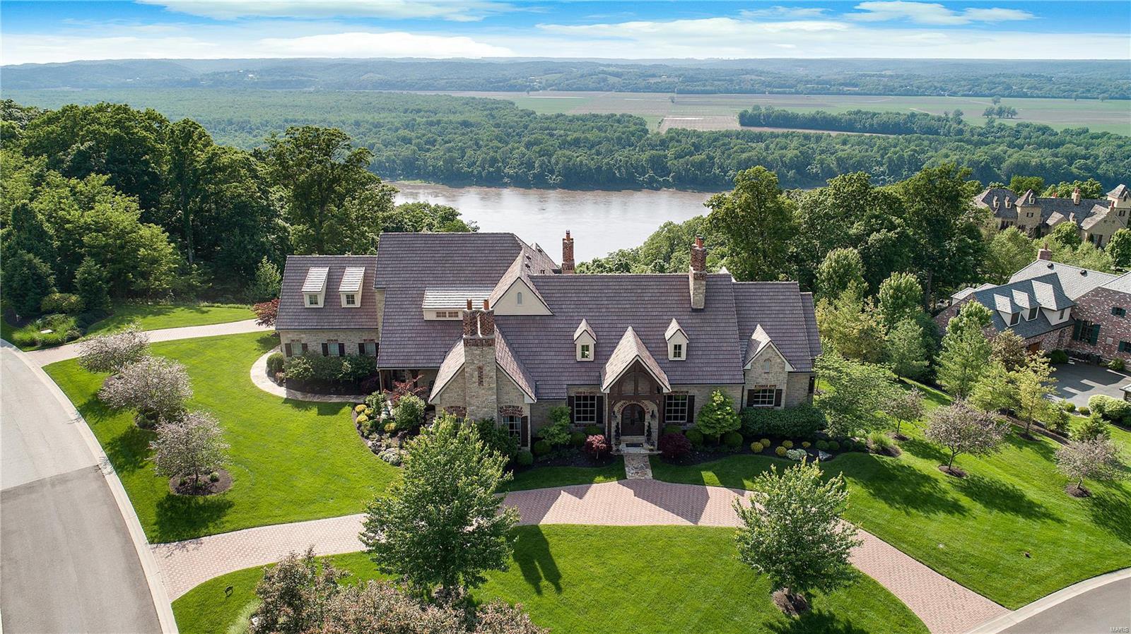Magnificent Stone Stunner with recent updates to many light fixtures & both powder rooms. A custom designed open floor plan offers spaces that flow & rooms that are utilized & not just walked past. Most of the floors & ceilings are stucco finished. Enjoy coffee on the porch off the den or by one of 6 fireplaces. Kitchen/breakfast/hearth rms are a combined space both cozy & magnificent. Kitchen has island w/counter seating for 8, Butlers pantry/beverage center, hearth room w/TV on stone frpl w/hearth that is a solid boulder. Covered stone patio off kit. LL offers fam rm w/box beamed crown molded & cove lit ceiling, extensive bar w/beer cooler, wine captain & wine closet, sound system w/ceiling speakers thruout, exercise room, built in book cases, lighted art niche, & card playing/entertaining area. Upper bedrooms enjoy their own sitting rm. Infinity edge pool w/waterfall is a perfect place to enjoy a panoramic river vista view