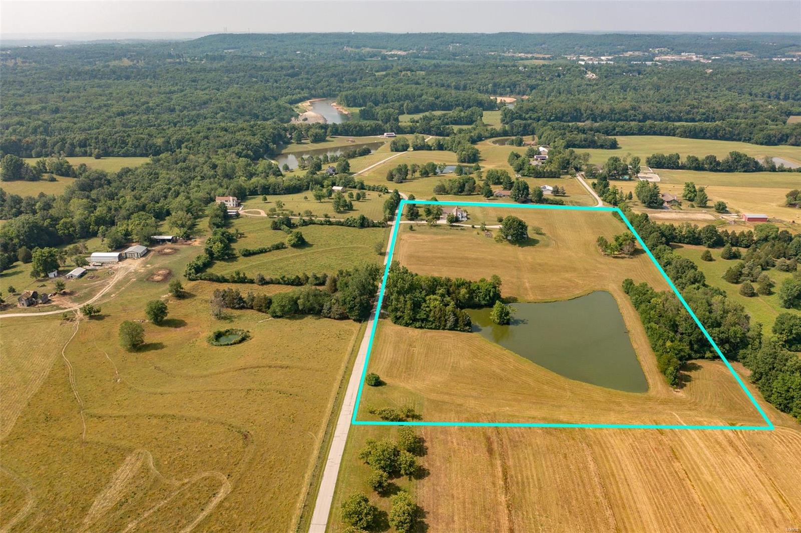 Private, off the grid, 16.5+/- level acre equestrian/fishing property w/a 1.8 acre stocked lake & 60’x36’ barn w/electricity & water. Fruit producing trees, blackberry bushes & a grape vineyard. Perfect for a weekend get-away or everyday living. Charming 4 Bedrm, 3 full & 1 half bath Cape Cod style home w/2,798+/- sqft. Walk into the foyer w/hickory wood flring through-out most of the ML. Home boasts formal dining rm, sitting rm w/full masonry FP, living rm w/2nd full masonry FP, walk-out to spacious screened in porch, wood ceiling w/wood beams, & windows. Kitchen features a wood ceiling, breakfast bar, & is equipped with a new dishwasher, double oven, electric cooktop, & new over/under cabinet lighting. Bedrm & updated laundry complete the ML. UL extends living quarters w/3 add'l bedrms, bonus rm, & large storage rm. Master suite boasts private deck w/new composite decking, 2 closets, & bath w/jetted tub/shower. Unfinished basement has great potential for additional living space.