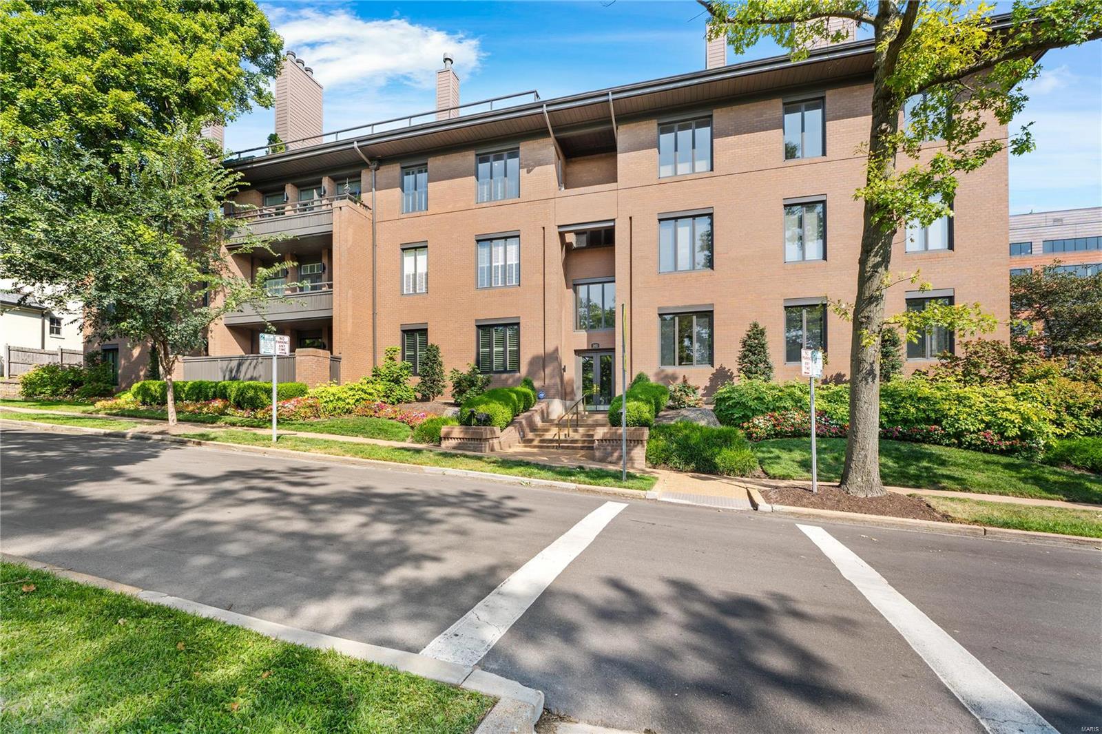 You CAN have it all - city living in a wonderful, walkable neighborhood. Elegance & sophistication abound in this fully renovated 3 bedroom, 2.5 bath first floor, one-level living condo. An abundance of natural light showcases the beautiful light wood floors & exquisite stone island & back splash. Gorgeous stone work in both full baths & plush carpet in the 3 bedrooms. Closets have been professionally designed with storage & function in mind. All windows have remote controlled, light filtering shades. Speakers in living, dining, family rooms & kitchen. Gas fireplace in living room & primary suite. Dining room has wet-bar & Thermador wine column. The open kitchen has paneled fridge/freezer, high end appliances, 2 ovens & 6 burner gas stove, w/large island that has storage on both sides. Lovely terraces off living room & primary suite. Two oversized parking spaces & 3 storage closets in garage. Enjoy dining, shopping & cultural events in Clayton...less than 3 blocks from your front door! Location: Corner Location, End Unit, Ground Level