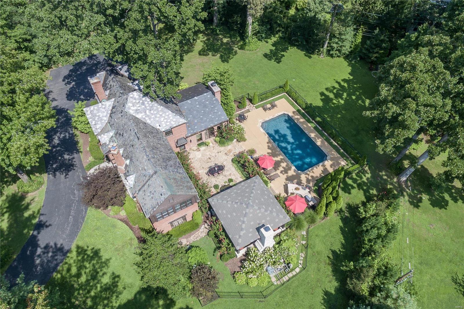 Spectacular private oasis, nestled in the trees at the end of a idyllic lane, in a highly sought-after Webster Groves neighborhood!  This home is an absolute WOW!  From the moment you enter the circle drive, you'll know this property is special.  Gorgeous inside and out, tastefully updated and thoughtfully expanded for today's lifestyles.  Stunning foyer with marble floor and curved staircase.  Spacious rooms and exceptional finishes throughout. The gourmet kitchen, with stainless appliances , opens to a striking great room addition with vaulted ceiling and stone fireplace. This room overlooks the breathtaking outdoor living areas with flagstone terrace, beautiful pool, Large Outdoor Room with fireplace, outdoor kitchen/bar and gorgeous yard/landscaping. You'll never want to leave home! The 2nd floor of the home features a luxurious master suite, plus three additional bedrooms and two full baths. Finished LL with rec room, bar and indoor SPORT COURT! Additional Rooms: Mud Room