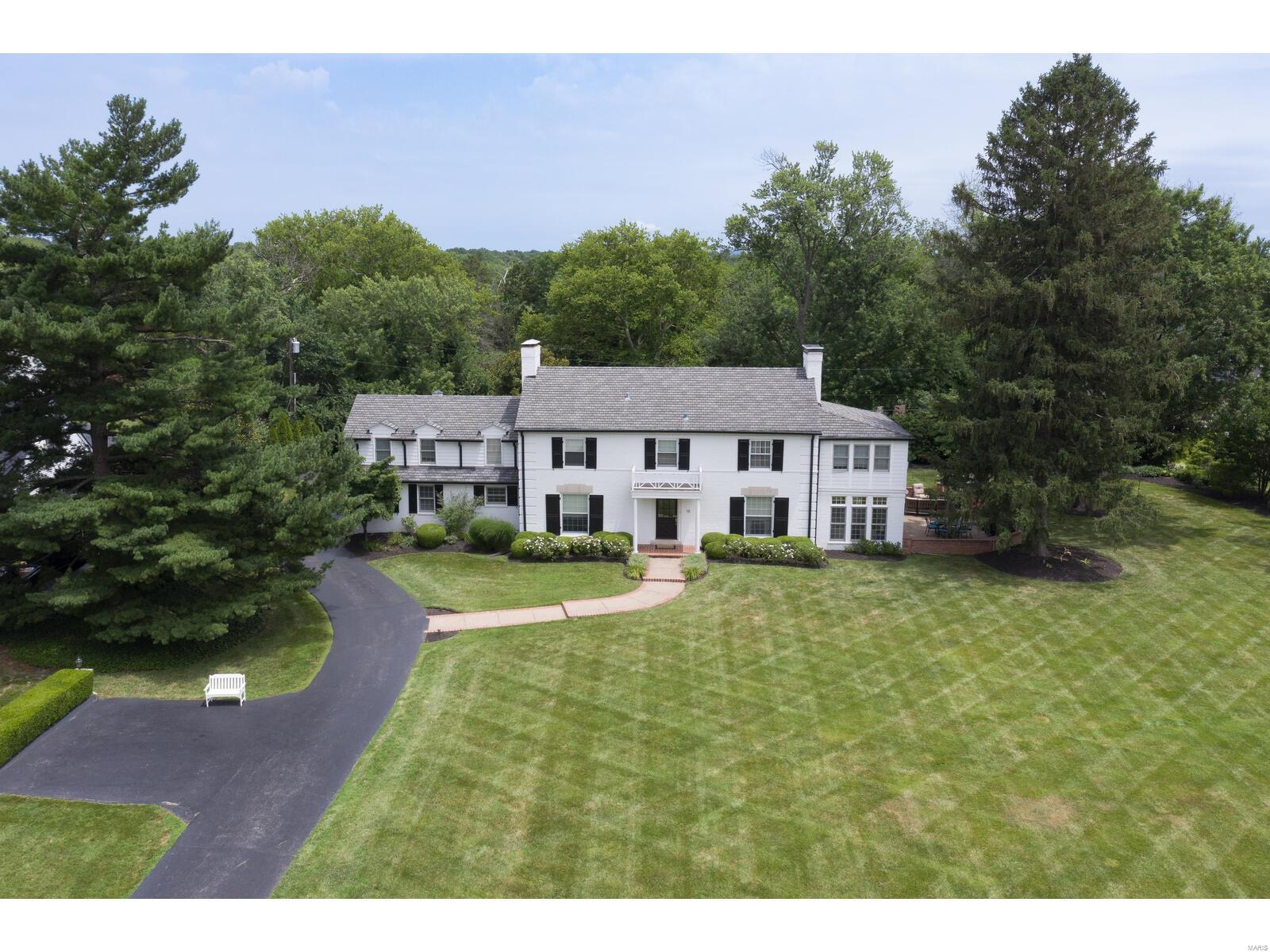 This stately brick 2-story will not disappoint the most discerning buyer, who will be enamored with the private, flat .92 acre lot on a prestigious horseshoe lane in Ladue School District. Once inside, you will appreciate the beautiful moldings, arched entries, gleaming hardwood, 3 fireplaces and the spectacular curved staircase. The LR features a 9' ceiling, built in cabinetry, and a see through fireplace. Two sets of French doors lead to the sunroom w/heated tile floor and access to the patio w/ outdoor fireplace. Gourmet cooks will enjoy this huge kitchen w/ gas cooktop, SS appliances, center island and a walk-in butler's pantry w/ glass front cabinetry and 2 drawer fridge. Rear staircase leads to the private guest suite. The primary BR suite offers 3 closets, a walk-in closet, private bath, fplc, and home office.* LL media equipment stays* bath in LL *MFLR laundry* 3 car gar*  With large patio and outdoor speakers, this home is set up perfectly for entertaining! Additional Rooms: Sun Room