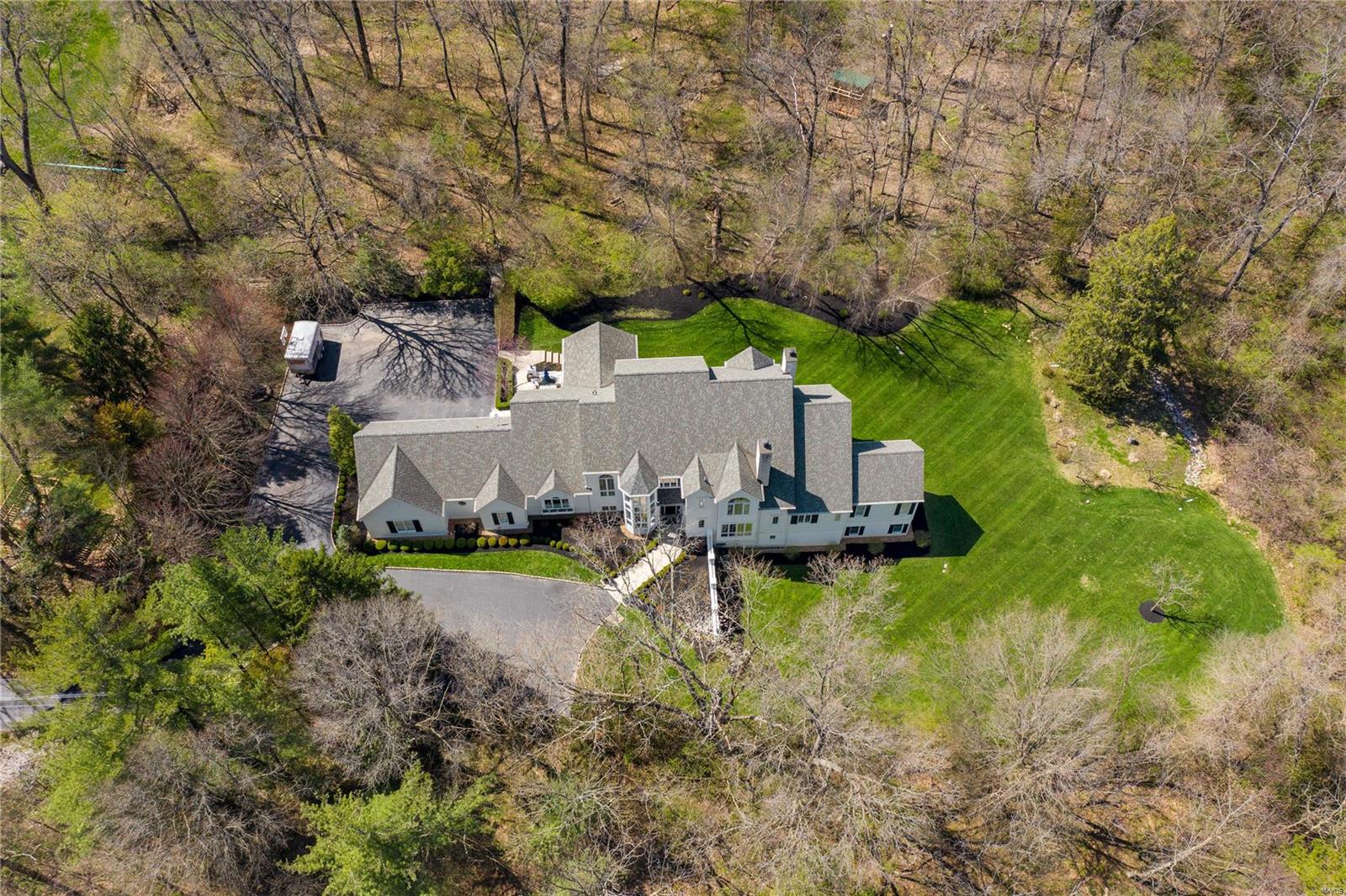 The ultimate in privacy and situated in one of the most coveted areas of Ladue, this 4 plus bed, 5 full/2 half ba home offers the best of modern design and picturesque outdoor spaces.  Lg windows and walls of glass doors flood this home with natural light even on a cloudy day.  The open concept updated kitchen with soaring ceiling, and center island flows seamlessly to a breakfast area and family area with access to a 3 sided screened outdoor liv rm.  The main flr master suite with newly renovated luxury bath offers his/her closets and a private screened porch perfect for those quiet nights at home.  A wood paneled den with fp, liv rm with beamed ceiling, din rm with custom temp controlled wine display, 2 half ba and laundry rm complete the first flr.  3 bedrm suites with walk in custom closets and updated baths are found on the second flr.  The walkout low lev offers additional family space, full updated ba, a custom office and tons of glass doors to the gorgeous landscaped yard.