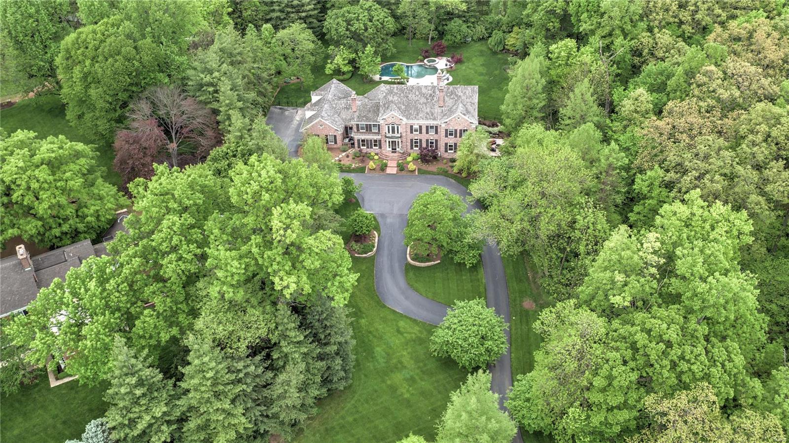 Gorgeous 24 year old custom home in the heart of Ladue. This residence has been renovated to include over
8500 sq ft of living space, gorgeous hardwood flooring, high end fixtures and walls of French doors leading
out to the private grounds including beautiful patios, waterfalls and stunning pool. The kitchen boasts a
beamed ceiling, custom Rutt cabinetry, large center island, Wolf/Subzero appliances, and Butler's pantry
leading to the formal dining room with fireplace. The 2 story family room/great room is perfect for
entertaining with custom builtins, fireplace, and wall of French doors leading to a large private patio. The
main floor master suite is perfectly tucked away with serene bath and private entry to the den. The second
level is complete with 4 large bedroom suites with custom closets. A glass enclosed wine room is the focal
point of the walk out low level with glass fireplace, bar, theatre room, workout rm and state of the art golf
simulator. Unbelievable home. Additional Rooms: Mud Room