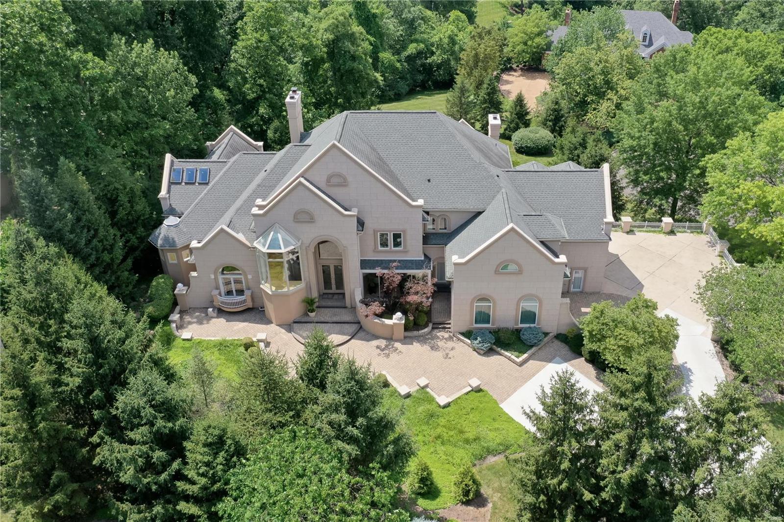 Magnificent. Modern Luxury on a very private cul-de-sac of 3 homes in Town and Country. 5 bedrooms, 9 baths, and over 9,500 square feet of refined living area. Hallmarks are an open concept with abundant glass and skylights. A main level primary suite walks out to a deck overlooking the pool, and enjoys an expansive bath with vaulted ceiling, jet tub, oversized shower and dual walk in organized closets. A two-story great room captures outstanding views. The chef's kitchen with island employs high end appliances, granite counters,  and opens to hearth and breakfast rooms. A two story water feature is a main focal point, with a 2nd stairwell servicing all levels wrapped around a pillar of cascading water. 2nd level has 4 bedrooms all en-suite. Above grade walk-out lower level features media and game rooms, additional sleeping area, and home office, as well as 2 full baths, one with steam shower. 1.27 acre lot. Steps away from popular Longview Farm Park and Masonridge Elementary school.
