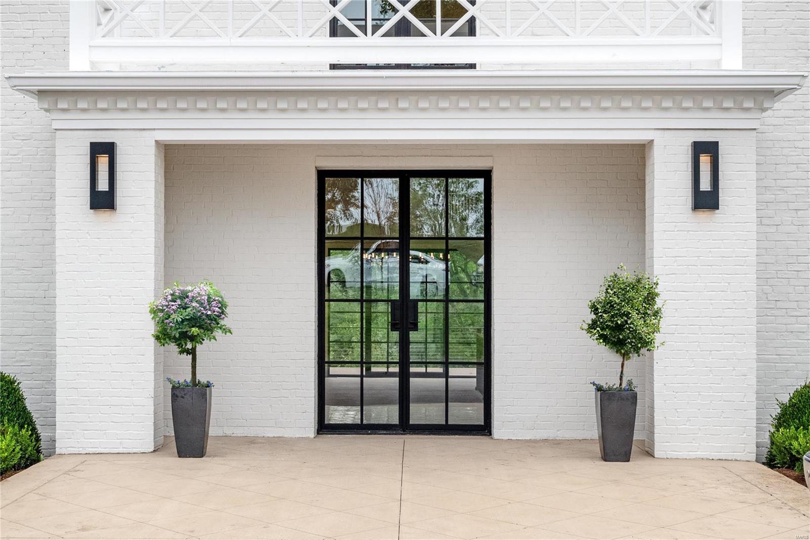 Welcome to this Hollywood Regency masterpiece that has undergone a meticulous renovation and expansion. Prepare to be enchanted as you enter this architecturally significant home that exudes modern elegance. Floor-to-ceiling windows invite the outdoors in, bathing the open floor plan in abundant natural light. A one-of-a-kind wine wall graces the entryway, while the breathtaking views overlook a lush canopy of trees. The sleek kitchen features a waterfall edge island that seamlessly connects to the dining room and hearth room, making it the ultimate space for entertaining guests. Host magnificent parties on the multiple terraces overlooking the pool. The main level primary suite is a luxurious retreat with its own fireplace, deck, custom closet cabinetry, and heated bathroom floors. Upstairs are four bedrooms, three full baths, and an inviting hangout area. Massive walk-out lower level includes an awe-inspiring glass-walled showroom garage. Truly a jaw-dropping residence.