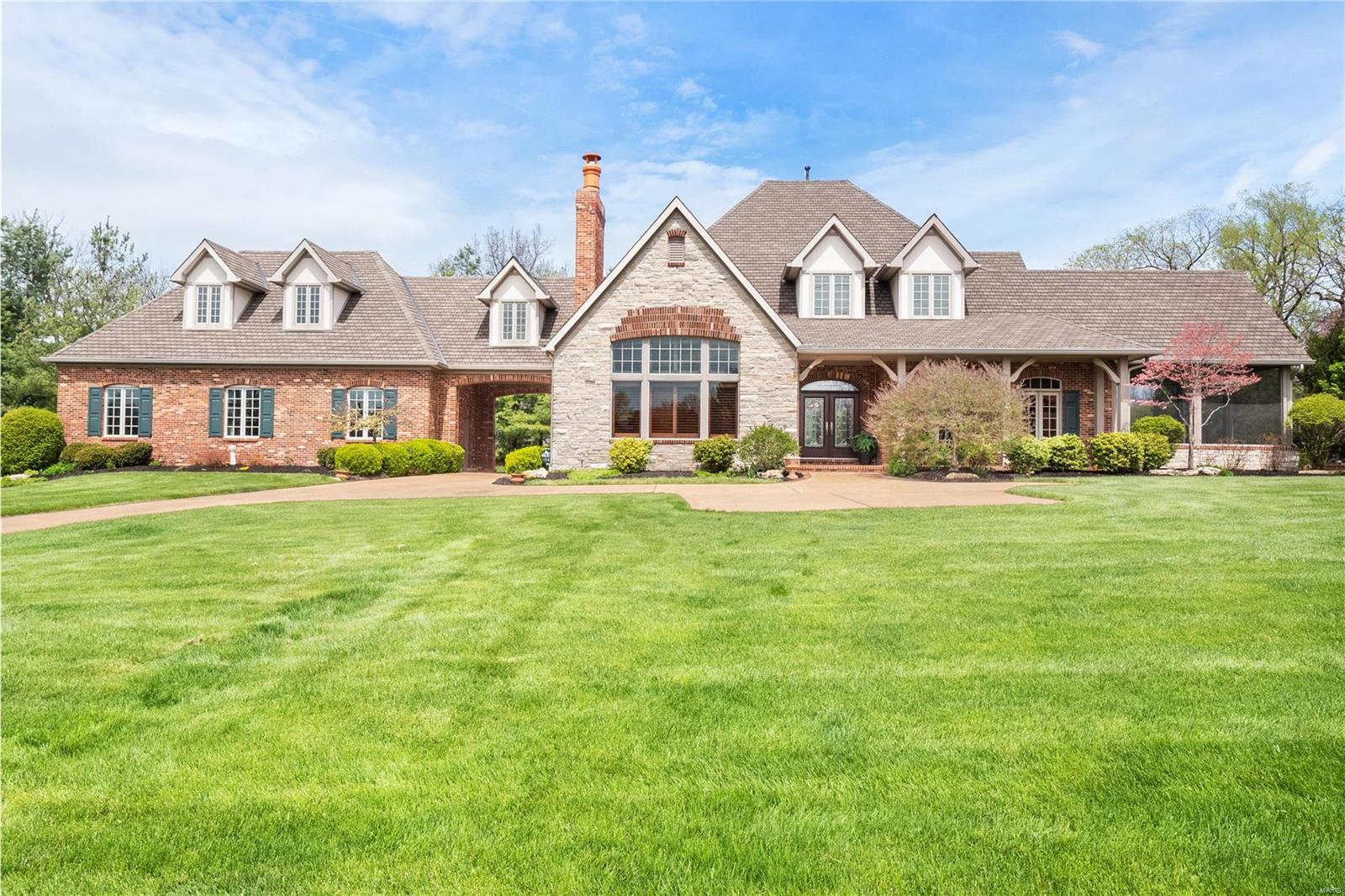 Newer construction (2006), this architecturally significant home has nearly 6,400 sq. ft. of living space.  Sophisticated finishes through out include walnut floors, paneled library w/ frplc., custom built-in bookshelves, vaulted ceiling & custom shutters.  Spacious entry foyer, extensive millwork, formal dining room w/ wetbar.  Gracious living room with frplc., wall of windows overlooks private yard.  Epicurean kitchen with high-end appliances, 42" cherry cabinets, large island,  huge breakfast room, butler's pantry, attached screened-in porch with vaulted ceiling overlooks cascading water feature for tranquil & relaxing evenings. .  1st floor primary suite with ensuite 2 baths complete w/ steam shower & walk-in closet.  1st & 2nd floor laundry rooms. 2nd floor has 3 spacious bedrooms, 2 full baths + a large, loft-like children's study/lounge.  HUGE finished, walkout lower level w/ 1,000 bottle wine cellar. 3 car garage, picturesque setting, expandable 2nd floor...ready for finishing. Additional Rooms: Mud Room, Wine Cellar