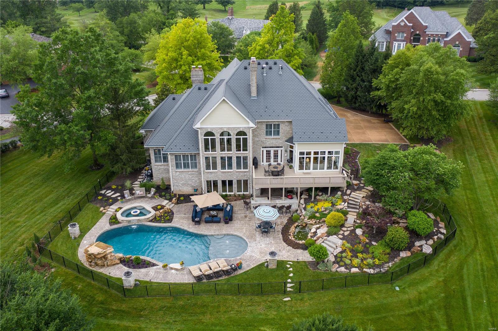 Stunning home located on the 10th Fairway of Lewis & Clark Country Club. Over 6300 SqFt of living space on over an acre lot. This home boasts a private pool w/grotto,spill over hot tub,waterfall feature,lush landscaping,several gas fire bowls,deluxe outdoor kitchen w/grill & pizza oven. Grand 2-story entry. Formal dining room feat detailed moldings. Rich office w/built-ins & gas fp. Kitchen feat granite countertops, dble wall ovens, lrg island w/brkfst bar. Cozy up in the sun room or spread out in the grand great room feat floor to ceiling windows, wood-look porcelain tiled floor,& dual sided gas fp. ML primary bedroom hosts a coffered ceiling,natural light,vast walk-in closets, & a spa-like bthrm w/large jetted tub & oversized shower. UL find bonus rm, 3 addl bdrms & 2 full bthrms. LL (walk out) hosts a bar,family rm w/3rd gas fp,billiard area, & bdrm. Changing rm, massive steam shower, & half bath. Country club,pool,tennis courts,lake,& walking trails gives a constant vacation feel. Additional Rooms: Sun Room