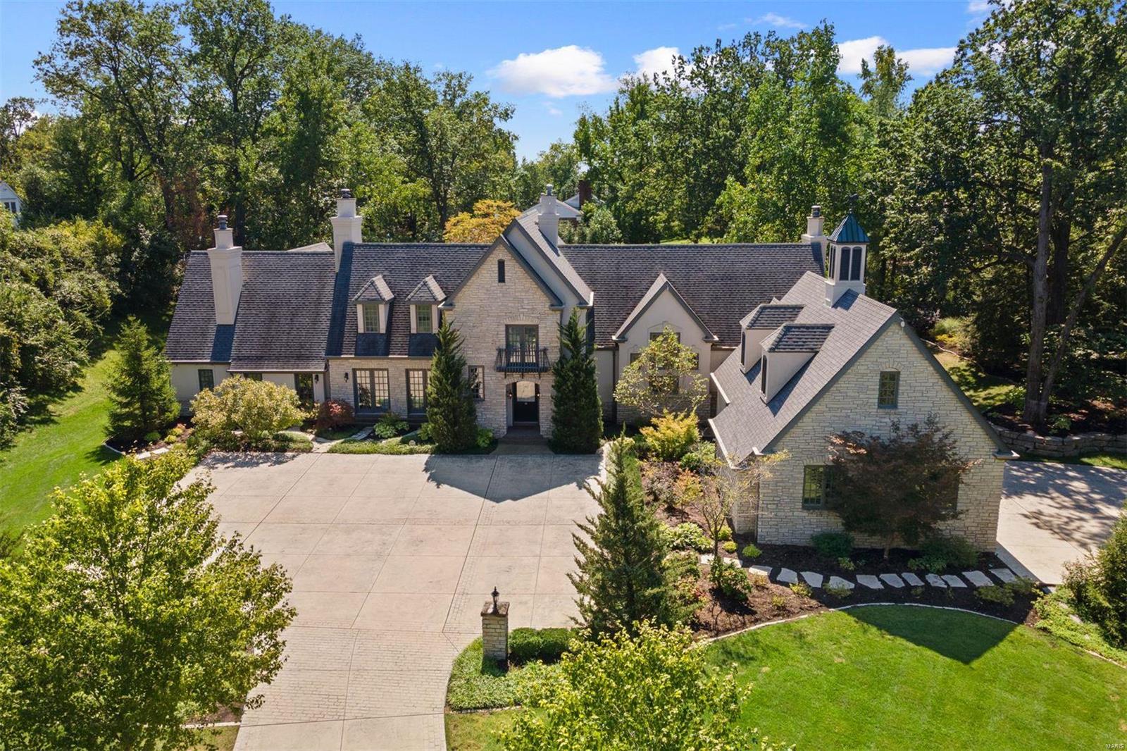 This gorgeous English Manor home on magnificent two acre lot has been renovated to perfection. Although the exterior of the home has all the charm of years gone by, the inside is chic and modern and will thrill even the pickiest of buyers! The main floor Primary suite is truly fantastic with ultra large closets and spa-bathroom with heated floors and steam shower. Upstairs there are 4 additional bedrooms all with their own baths and great closets. Luxurious appointments throughout with soaring ceilings, a chef's kitchen with custom hood,  and enormous waterfall island. There are three gas fireplaces throughout. Gorgeous dining room and living room are open and bright with light pouring in all the French doors. Lower level has custom gym, bath, and great space for entertaining. The landscape is gorgeous and updated with fabulous parking in front of home. Prime Ladue neighborhood could be yours. Fenced yard. Prepare to fall in love!
