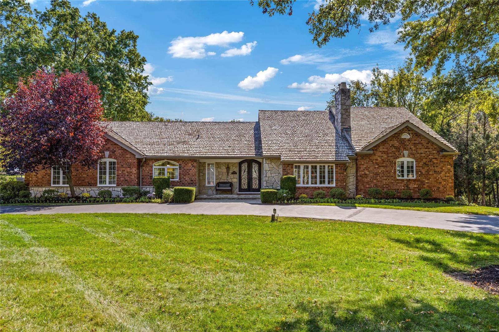 This beautifully designed brick & stone 1.5 Sty features exceptional craftsmanship & distinctive architectural elements throughout. Marble entry foyer leads to well-appointed study, elegant dining room with built-in china cabinets & stunning great room with beamed cathedral ceiling, marble fireplace flanked by display cases & French doors to atrium. Marc Christian-design kitchen with glazed buff cabinetry, granite countertops, commercial grade appliances & 10’ center island adjoins breakfast room & vaulted hearth room with fireplace. 1,200 sq ft primary bedroom suite combines the enjoyment of a marble fireplace with lavish bath with steam shower spa & jetted tub. Oak staircase accesses 2nd & 3rd bedrooms & hall full bath. Lower Level includes recreation room with 5th fireplace, 2nd kitchen, 3 additional bedrooms & full bath. Atrium door open to outdoor living area with patio with grilling station & full-height fireplace, fire pit, hot tub & pool surrounded by landscaped gardens. Additional Rooms: Sun Room