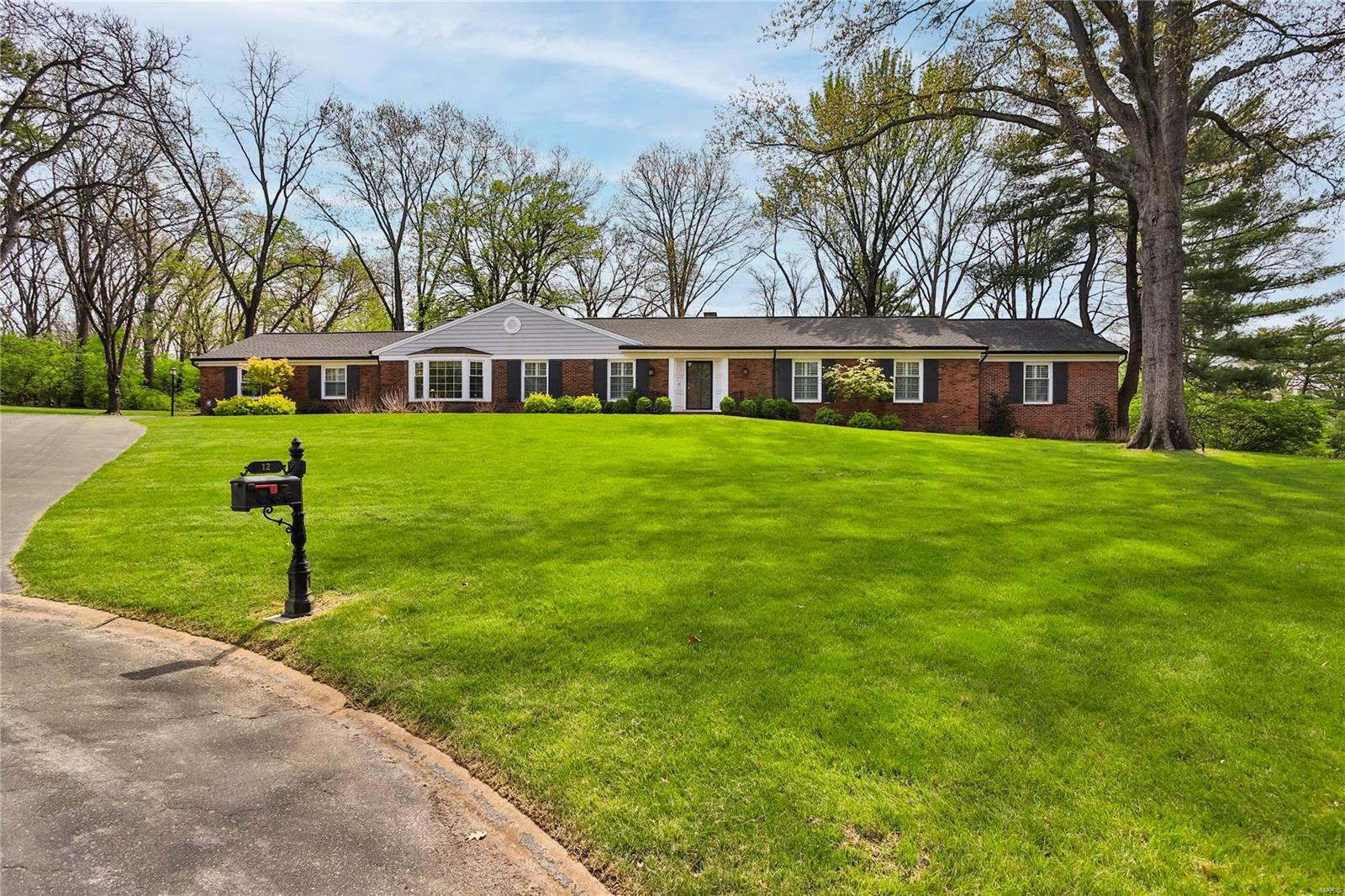 This sprawling Frontenac brick ranch sits perfectly on a large private lot. Step inside to find a gracious entry opening to a large living room with gas fireplace, built-in bookshelves & wood floors. The formal dining room features a large bay window & is the perfect spot for entertaining family and friends. The updated kitchen includes custom cabinets, stainless appliances, center island, coffee bar and plenty of room for a kitchen table. Off the kitchen you will find a main floor laundry and charming powder room. A large light filled family room has a fireplace, more built-ins and provides wonderful views of the park like yard. The family room has access to  a large brick patio with gas firepit. The primary suite has double closets and newer bath. 4 additional bedrooms and 2 newer baths complete the main floor.  Downstairs you will find an enormous lower level with loads of additional living space. Other features include Ladue schools, 2 car garage, wood floors & plantation shutters.