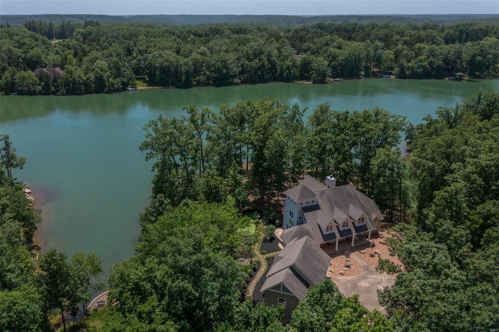 Spectacular lakefront home at Innsbrook Resort! Fall in love with the Cape Cod charm, soaring ceiling heights, spacious layout, and level access to the lake. Over 450' of shoreline! The gorgeous and oversized custom kitchen, with SS appliances and granite counters, opens to the vaulted great room. Take in the massive stone FP and wall of windows overlooking the lake. Clerestory windows adorn the delightful breakfast nook. Retire to the roomy master suite with it's own sitting area and custom bay windows. So many options in the airy loft. Entertain, office space, bunk area, or game room. 2 comfortable guest rooms plus a bar and family room complete the basement. Oversized 3 car garage (golf cart included!) offers plenty of parking. Try your luck at the putting green, sip a drink at the pergola, watch the birds from the freshly stained deck, or launch a pontoon boat for a cruise. The architectural detail, quality of appointments, and private setting make this lake home a sure winner.