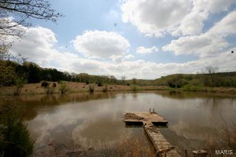 Own a piece of Missouri paradise.  158.6 acres of rolling hills, woods, fenced pasture and lake all near Boone Hollow golf course. This is a rare chance to purchase so much beauty Only 23 minutes from Hwy 40.    Land is currently being used for hunting, cattle, and recreation.     Call you agent today to schedule a private tour.   Must have truck or SUV to be able to drive through creek in photos to access gate.   Gate is locked and requires agent key to access.