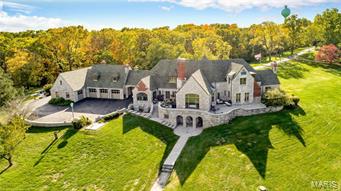 A release from the day’s stress overcomes you when the double-gates open granting access to the renown Castle of Montebello. Pull through the porte-cochere & step foot into your fortress of luxury. Located 30 minutes from St. Louis, this 60 acres estate is located on the hills above the Meramec & Mississippi Rivers. The stone home was built by a Magic Chef heir with no expenses spared. The foyer is glamourous with a sweeping staircase. Great room with a floor to ceiling window featuring a massive limestone fireplace, timber-beamed ceiling & a Juliette balcony. The kitchen features gas stove & fine appliances ready to create the most exuberant feasts to be served in the formal dining room.  The master suite has a new bath with a jetted tub & shower wet room. Lower Level with recreation room with a wood-burning fireplace & a 1000 bottle wine cellar! New windows. Carriage house with recreation room. 2 extra bedrooms above the garage. 5 stall stables. Walkable to restaurants in Kimmswick. Additional Rooms: Sun Room