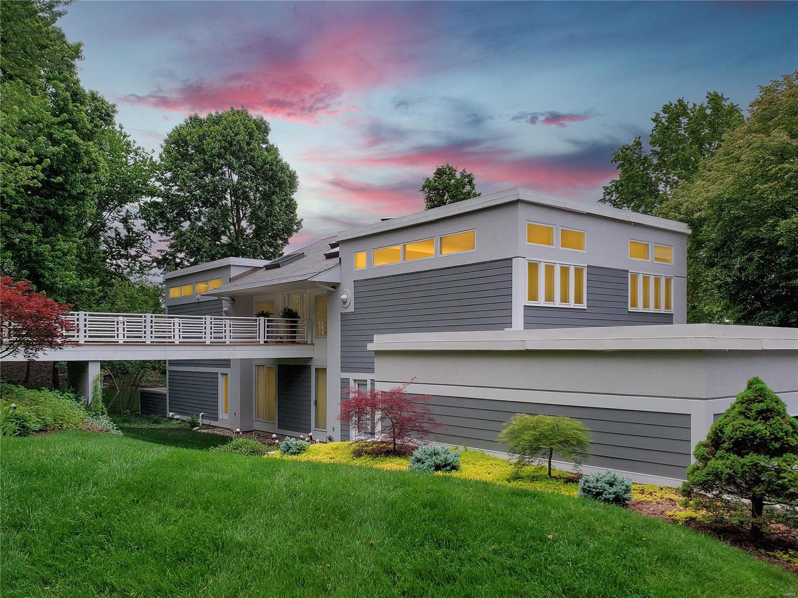 Stunning contemporary home designed by Frank Lloyd Wright apprentice T. Victor Stimac on private 3 home street in Ladue. Walk across the bridge and step inside to an abundance of natural light and architectural interest in every direction. Gorgeous master suite with fireplace, built ins, private deck and amazing master bath with his & her vanities & closets leading to huge jetted tub & steam shower. 2 additional light filled bedrooms also on upper level, one w private deck. Head downstairs to the large and sophisticated great room featuring impressive 2 story fireplace and wall of glass doors leading to the huge travertine deck. Kitchen features top level appliances and leads to both deck and oversized 3 car garage. Media room, office/flex space, 2 full baths, laundry rm and 2 more bedrooms w shared deck complete main level. Recently finished basement includes family room, half bath and rec room with huge bar. Low maintenance Hardie board siding and slate tile roof, plus so much more!