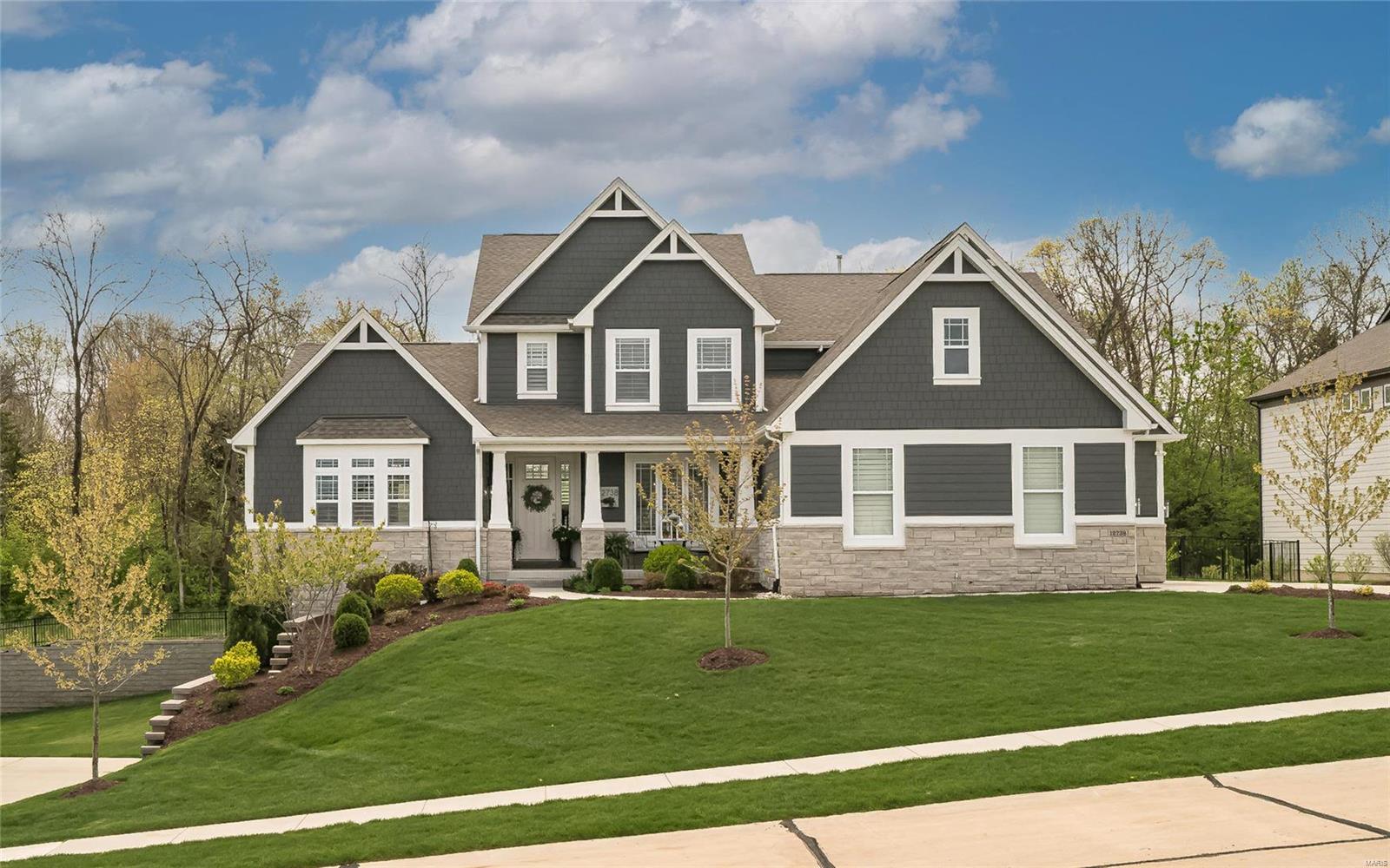 Beautifully designed 1.5 Sty from award-winning McKelvey Homes. This former display features sophisticated interior detailing & appointments throughout including wide plank hardwood flooring, soaring ceilings & plantation shutters. Impressive entry foyer leads to formal dining room & stunning great room with 11’ ceiling & wall of windows with private wooded views. Designer kitchen with 42” cabinetry, quartz countertops, stainless steel appliances, 6’ center island & butler’s pantry adjoins light-filled breakfast room & hearth room with stone fireplace with shiplap surround & built-in bookcases.  Coffered master bedroom suite offers a relaxing retreat with His & Hers walk-in closets, sitting area & vaulted bath with freestanding tub. Oak staircase accesses 3 additional bedrooms, 2 with Jack n’ Jill bath, hall full bath & bonus room with beverage center. Outdoor living area includes resort style pool with waterfall wall surrounded by landscaped gardens plus deck & stamped concrete patio.