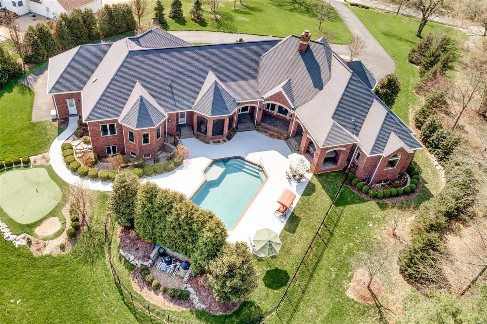 Luxurious brick and stone ranch home perfect for all your entertaining. The homes veranda wraps around the home & from every room you have views of your almost 2 acre estate, gorgeous lot, pool, waterfall, landscaping galore, & putting green. This Custom built home that has fantastic space w/ over 6300 sq ft in living space, 4 beds, 4.5 baths, 4 car garage, & mother-in-laws quarters in the lower level w/ separate family room, bedroom and bath. Master bedroom suite with sitting room. A stunning home that boasts a gorgeous entryway with circle drive, solid custom Mahogany front door, great room with gas fireplace, office with custom wood working, gourmet Kitchen with custom cabinetry and granite countertops. Lower level is the perfect entertainment center with exercise room, bar area, media room/family room, billiards room, and game room. All of this within 20 minutes of downtown and your favorite baseball team. This seller has spared no expense with the details and quality in this home.