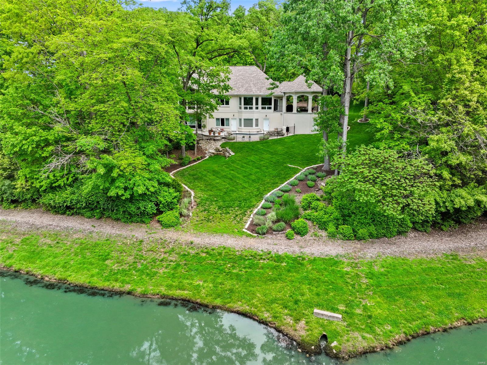 Experience luxury living in this exceptional custom-built atrium ranch, boasting 6 beds, 4.5 baths, & almost 5,000 total sq ft. Set among mature trees w/ serene lake views on a 1.3 acre lot, this home offers unparalleled privacy & stunning vistas from every room. The grand entrance welcomes you w/ soaring ceilings, a wall of windows, cozy fireplace, & built-in bookshelves. Enjoy the gourmet kitchen featuring custom cabinets, spacious center island w/ marble counter, quartz counters, subway tile backsplash, & stainless appliances all open to a breakfast room & sitting area w/ wet bar. The expansive master suite impresses w/ large walk-in closet, detailed molding, & spa-inspired bath. The finished LL is perfect for gatherings, offering: family room, 4 beds, 2 baths, ample storage, & walk-out access to a backyard oasis complete w/ patio, gazebo, in-ground pool w/ waterfall overlooking the lake. This home truly has it all! Welcome home! Additional Rooms: Mud Room