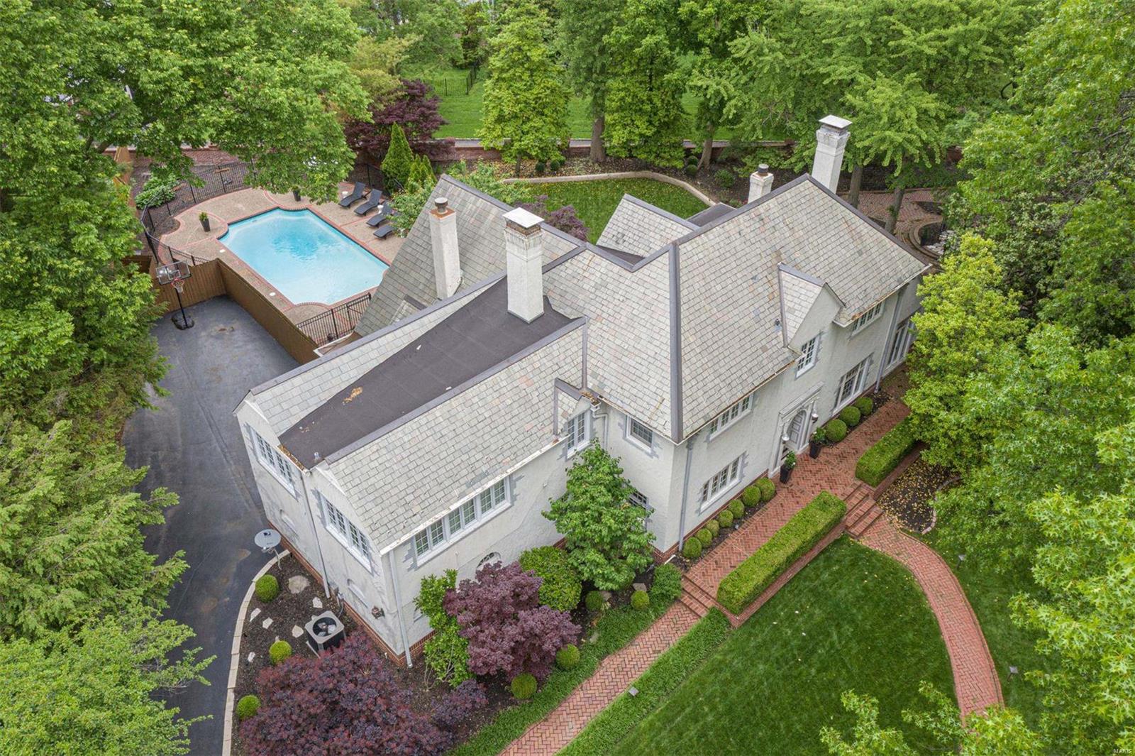 Located on a ¾ acre lot in Clayton is this stunning home. Walkable to Washington University, Oak Knoll Park, Demun, Wydown Middle, Glenridge Elementary & more. As you enter the home you will be greeted by the gracious foyer with a marble floor & sweeping staircase. Expansive living room with bright windows, dark hardwood floors & gas fireplace. Off the living room is a solarium & sunroom with a fireplace. Formal dining room. The kitchen features custom wood cabinets, Sub-Zero refrigerator, Miele dishwasher, 5-burner gas cooktop, peninsula island, desk, bar & butler’s pantry. The kitchen opens to a family room with sliding glass doors that look out onto the backyard. Heated saltwater pool with expansive decking. The primary suite is lovely with an abundance of closets & French doors that open to a Juliette balcony. 2nd-floor laundry room. Finished lower level with recreation room. Side yard with patio & wrought iron gazebo. Irrigation system. Slate roof with all new copper throughout.