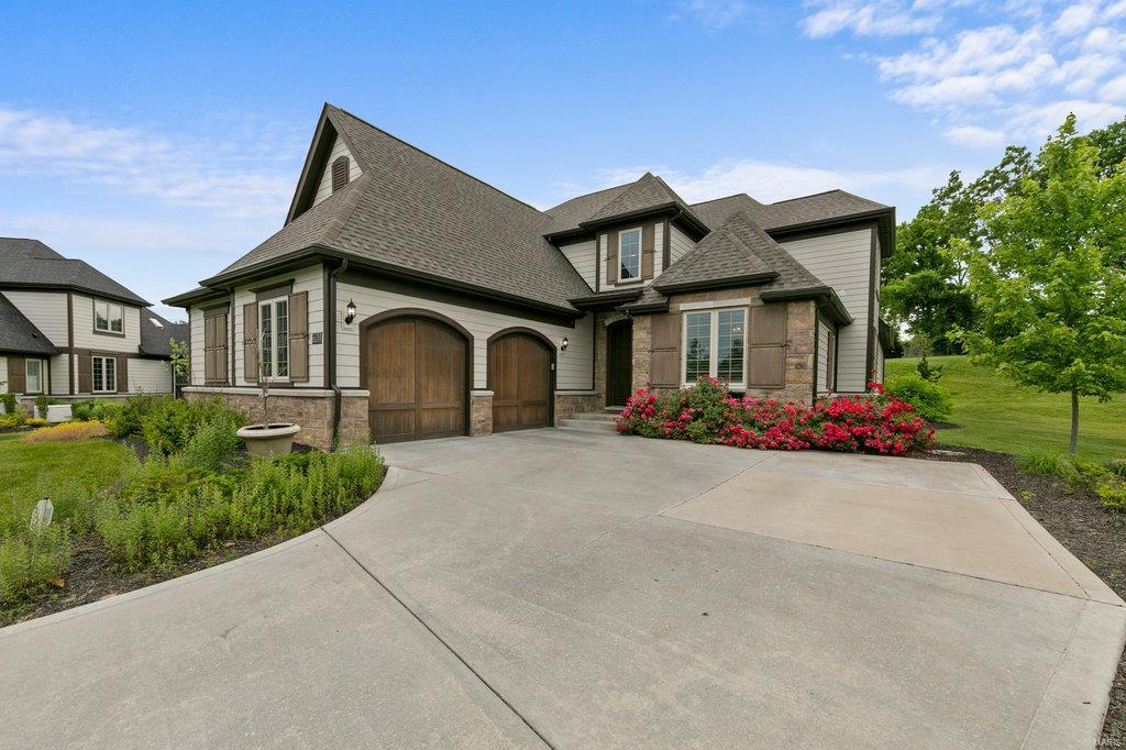 Stunning 1.5-sty home in highly sought after Ladue neighborhood! Step inside the 2-sty foyer and notice the hand-scraped wood flooring through out, chair rail, millwork & plantation shutters! The spacious open floor plan offers a gourmet kitchen with 42" cabinets, granite counters, stainless steel appliances, center island, butlers pantry, writing desk & adjoining breakfast room with convenient access to the patio and private backyard. The 2-sty great room features a custom barn wood coffered ceiling, large ceiling fan as well as a floor to ceiling stone fireplace. The master suite is on the main floor offering his/hers walk in closets as well as adjoining luxury bath with steam shower and soaking tub. The 2nd floor offers 3 additional spacious bedrooms & a full bath! Additional living space can be found in the finished lower level featuring family room, wet bar, 5th bedroom and another full bath! Additional amenities include oversize 2 car garage & main floor laundry! Sure to please!