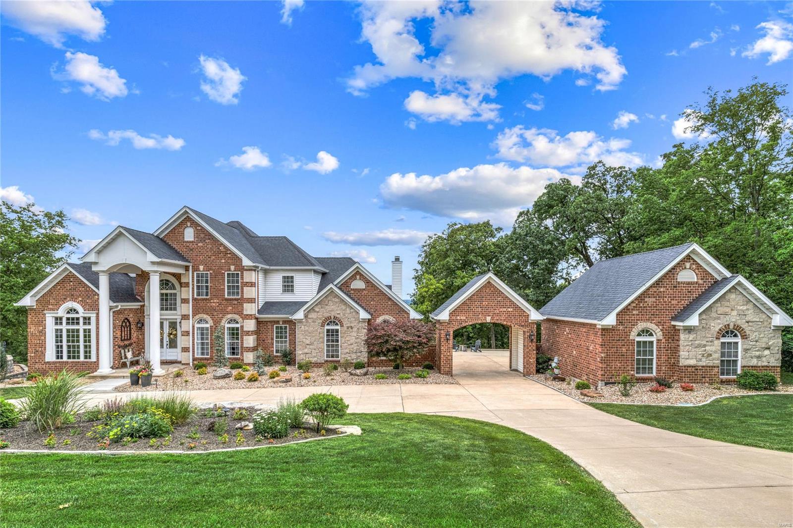 Spectacular 7200 sf brick & stone 1.5 Sty in prestigious Whitmoor Country Club. Situated on a premium 1.5-ac lot overlooking the Missouri River Valley. Dramatic 2-sty entry foyer leads to private study with custom built-ins, formal dining room & stunning great room with cast stone fireplace & 2-sty bow window that offers unsurpassed vista views. Designer-inspired kitchen with white cabinetry, quartzite countertops, Dacor appliances & 7’ x 6’ center island adjoins light-filled breakfast room & vaulted hearth room highlighted by floor-to-ceiling fireplace. Spacious primary bedroom suite with beautifully appointed bath with shower spa & jetted tub provides a relaxing retreat. T-staircase accesses 3 additional bedrooms, 1 with ensuite bath & 2 with Jack n’ Jill bath. Lower Level entertainment space includes recreation room with stone fireplace, gathering bar & media room plus 5th bedroom & full bath. Professionally landscaped grounds with 2 decks, hot tub, porte cochere & 2 2-car garages.