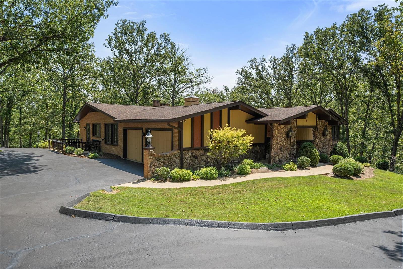 Discover luxury meets equestrian living on 17 serene acres. This mid-century estate is a dream for horse enthusiasts, offering 4 beds, 3.5 baths, and unmatched privacy. The property features a spacious, high end horse stable with multiple turnout/paddock areas, for those seeking the ultimate facility for their horses. This home exudes elegance with a modern kitchen featuring granite countertops, custom cabinetry, and high end appliances. Sun-drenched interiors include a fresh open floor plan, two wood-burning fireplaces, and an oversized primary suite with a superb walk-in closet. Big windows overlooking lush, well manicured, tree-filled views of nature, while the partially finished walkout basement adds extra living space with a wet bar and bathroom. 12 stall custom stable includes foaling stall, grooming/wash rack, barn lounge area, hay and equipment storage areas. Property also has a fenced arena area.