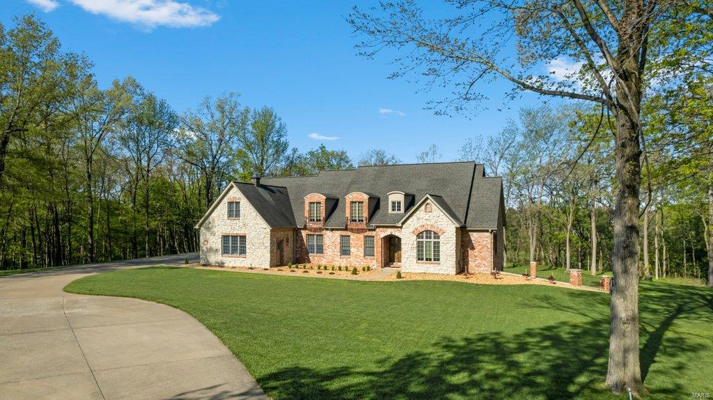 This custom home has been completely remodeled with made-to-fit S&W cabinetry in the kitchen, bathrooms, and the new custom bar. The kitchen offers a beautiful open concept with a center island sink, kitchen-aid appliances, 6-burner gas cooktop, double oven, and a large laundry room on the main level. The owners' en-suite offers an oversized walk-in shower, garden tub, double vanities, and his-and-her walk-in closets. This magnificent property sits just out of the city limits on 3.3 acres, complete with a mature forest and a peek through the trees at a pond. The upstairs has, 3 large bedrooms, 2 full baths with a full size living area and 2nd laundry. The lower level is the perfect addition to this home with a bedroom, full bathroom, office, custom bar with a beer fridge and wine fridge, John Deere room, 3 storage areas with room for a home gym. The details of this home will amaze you with so many features to see, but the cornerstone of this home is that it was built with 2X8 studs.